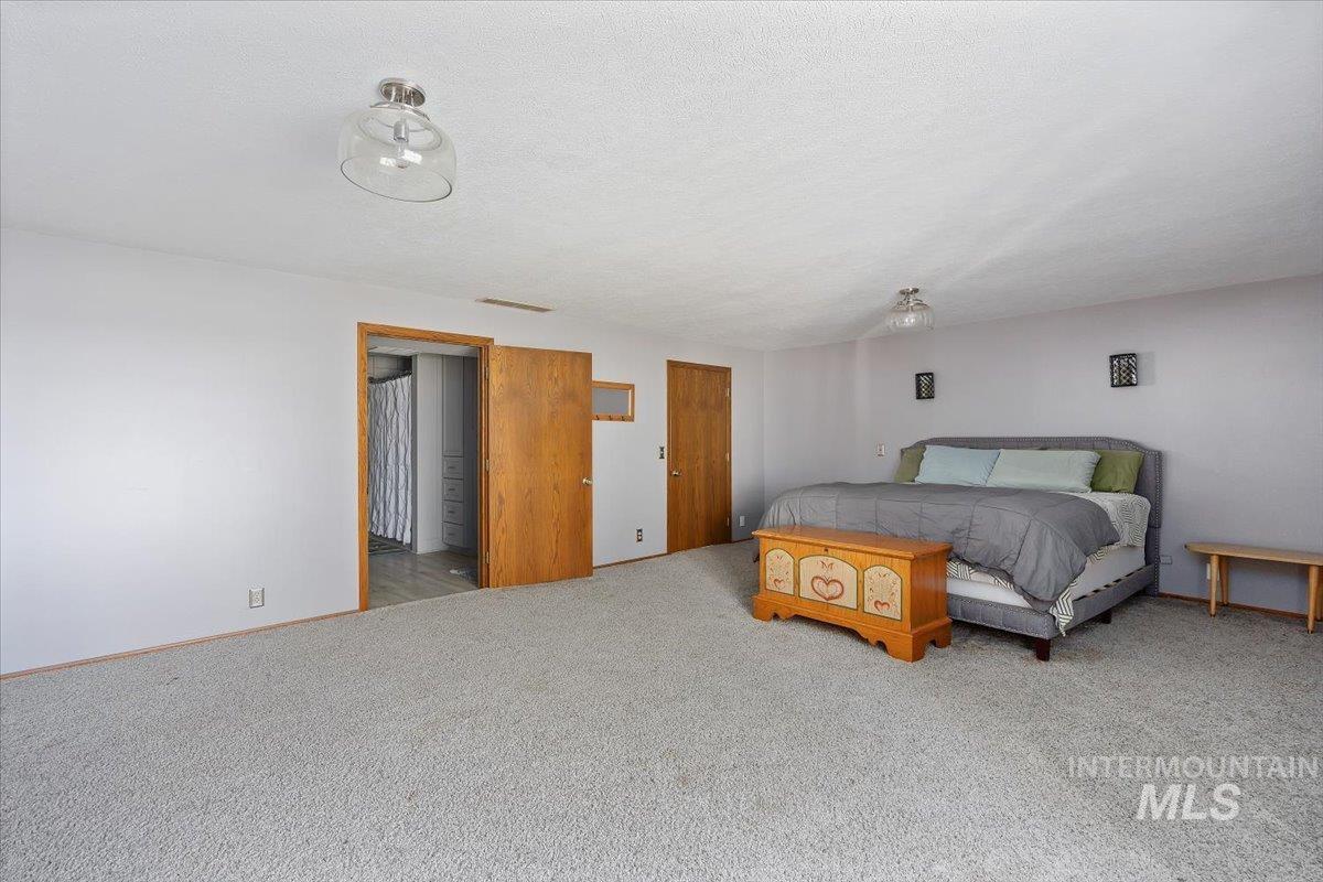 Carpeted bedroom with baseboards and a textured ceiling