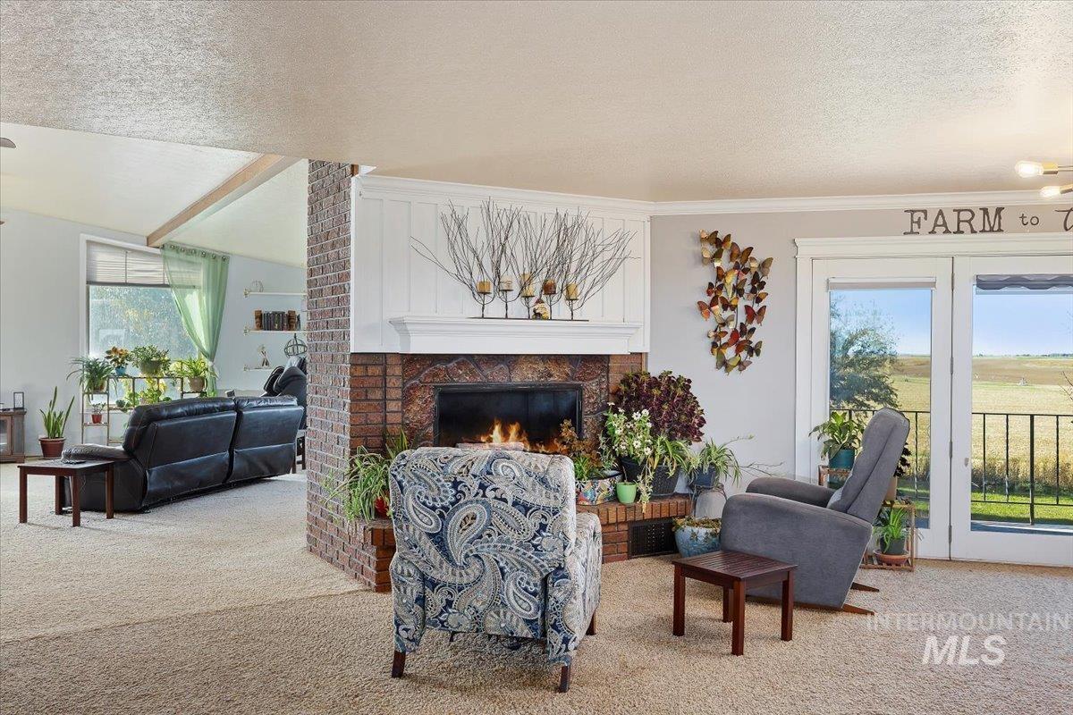 Carpeted living area with a brick fireplace and a textured ceiling