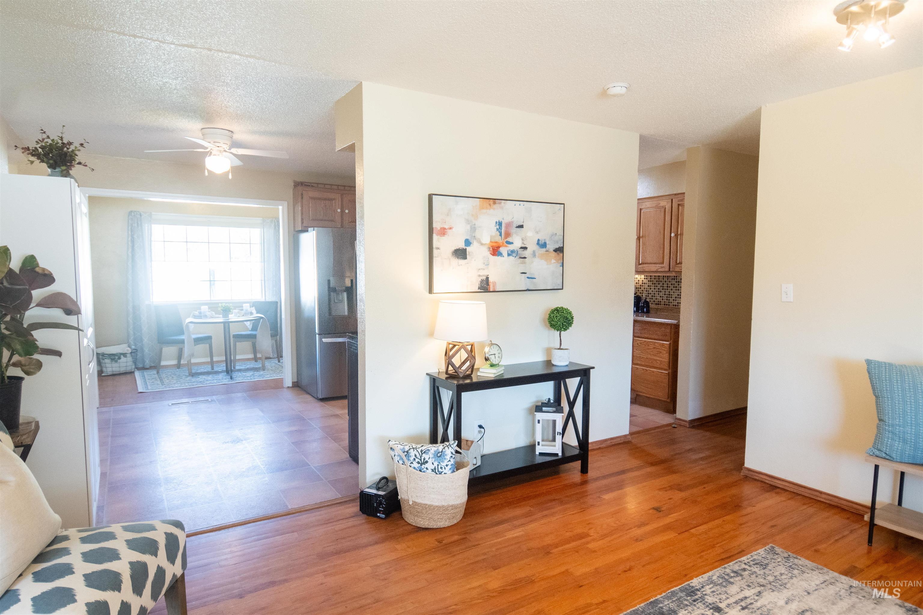 Corridor featuring light wood-style floors and a textured ceiling