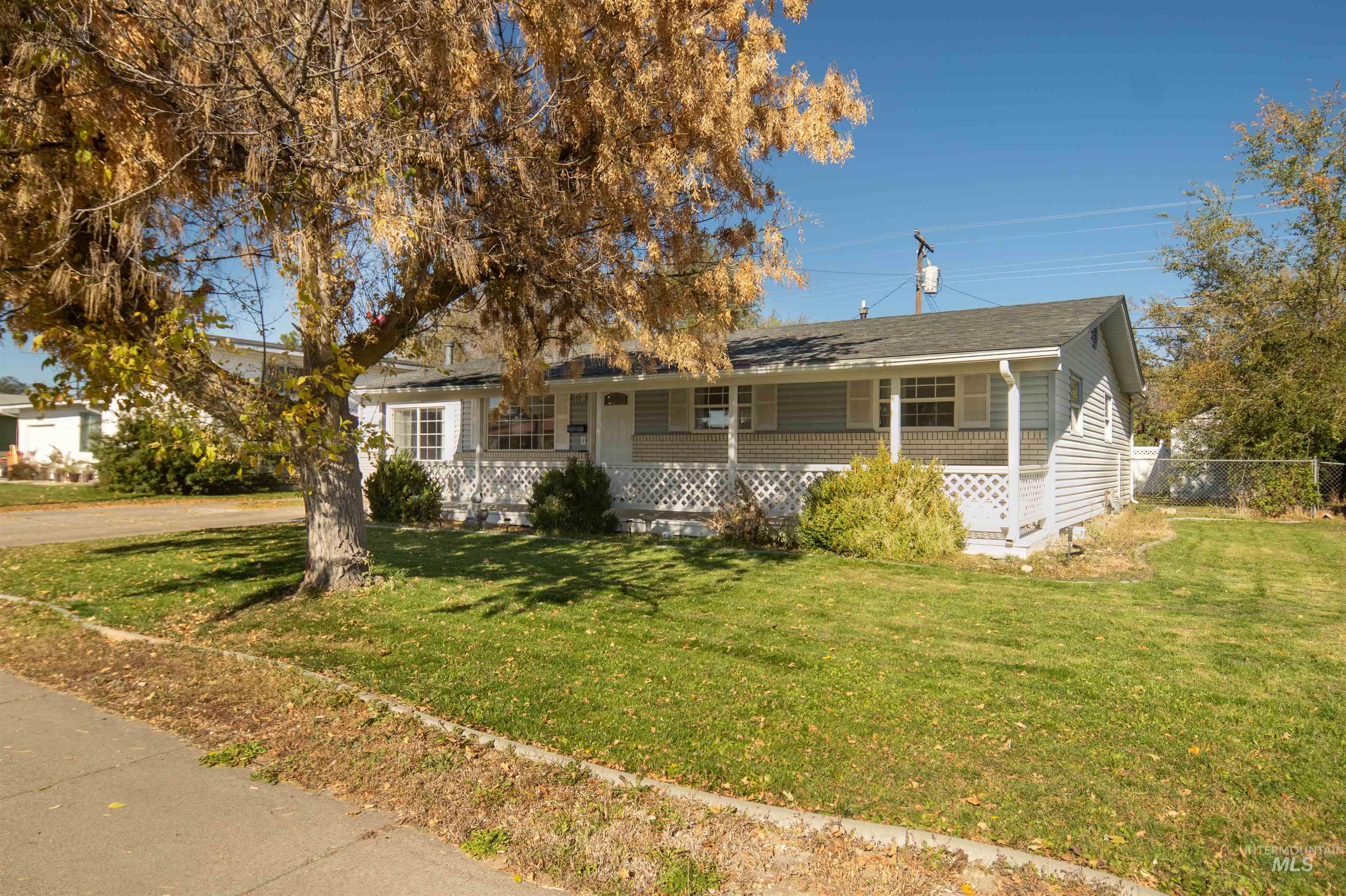 Ranch-style home featuring a front lawn and covered porch