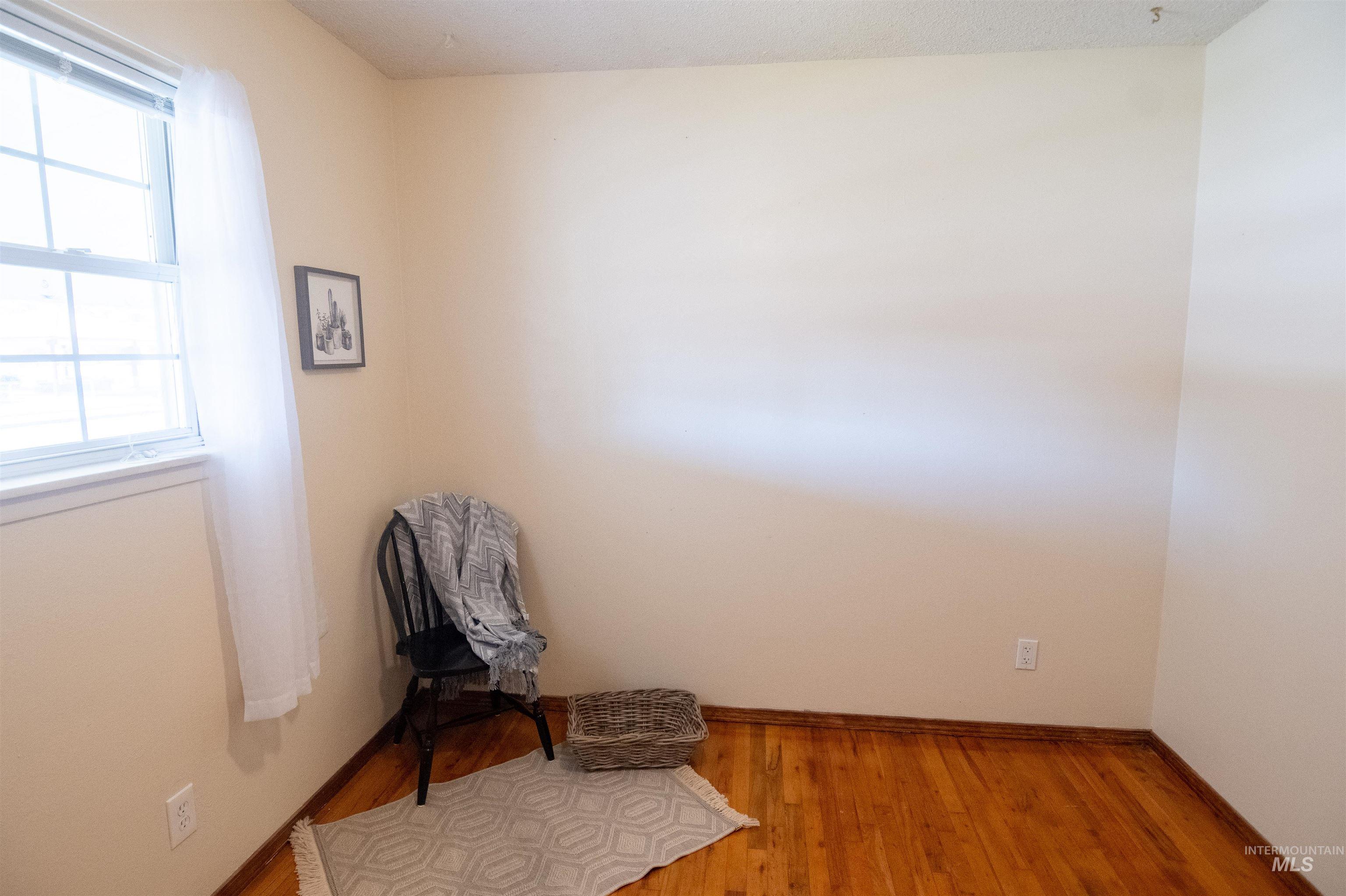 Unfurnished room with wood finished floors and baseboards