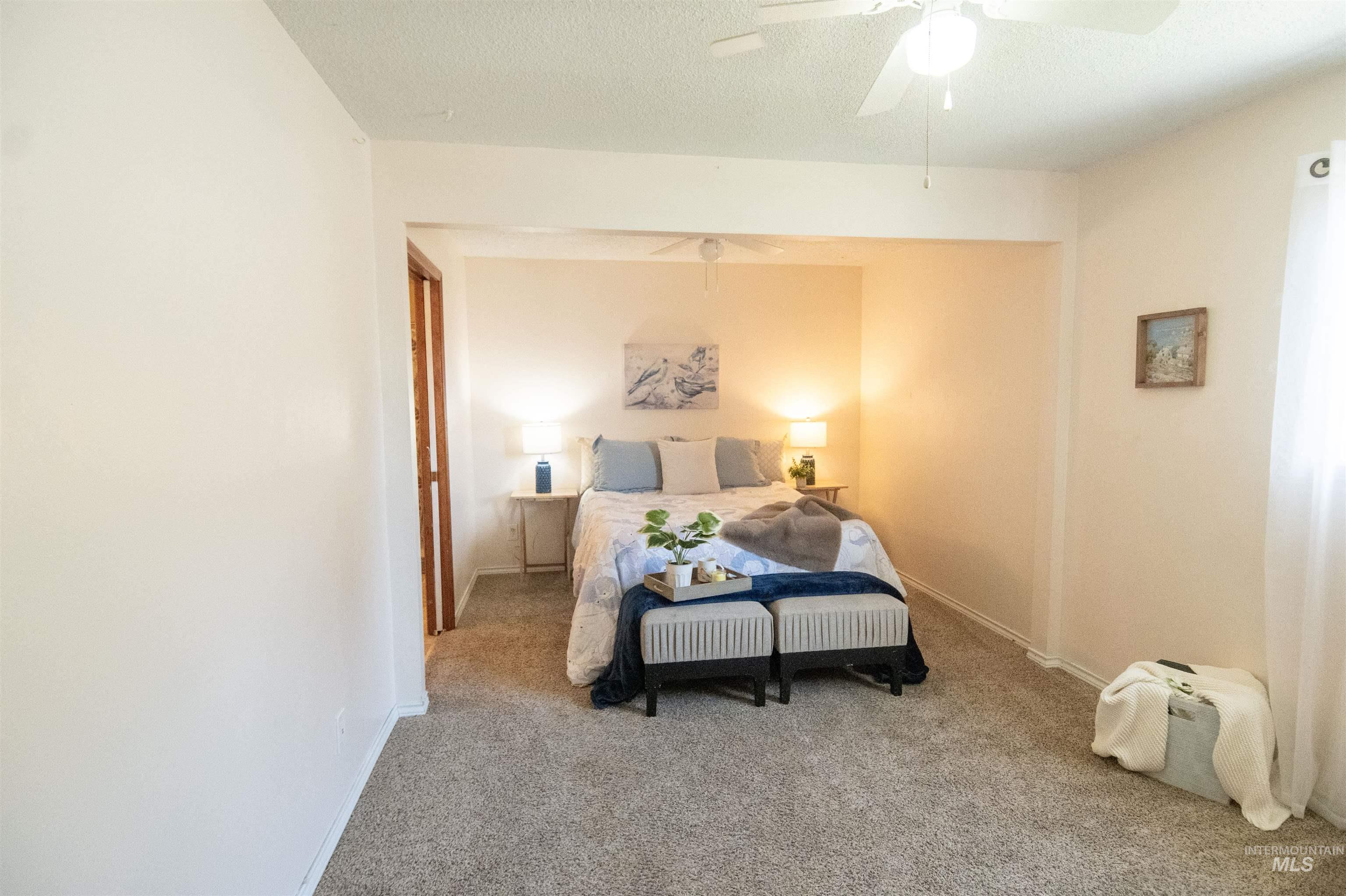 Bedroom featuring carpet floors, a textured ceiling, and a ceiling fan