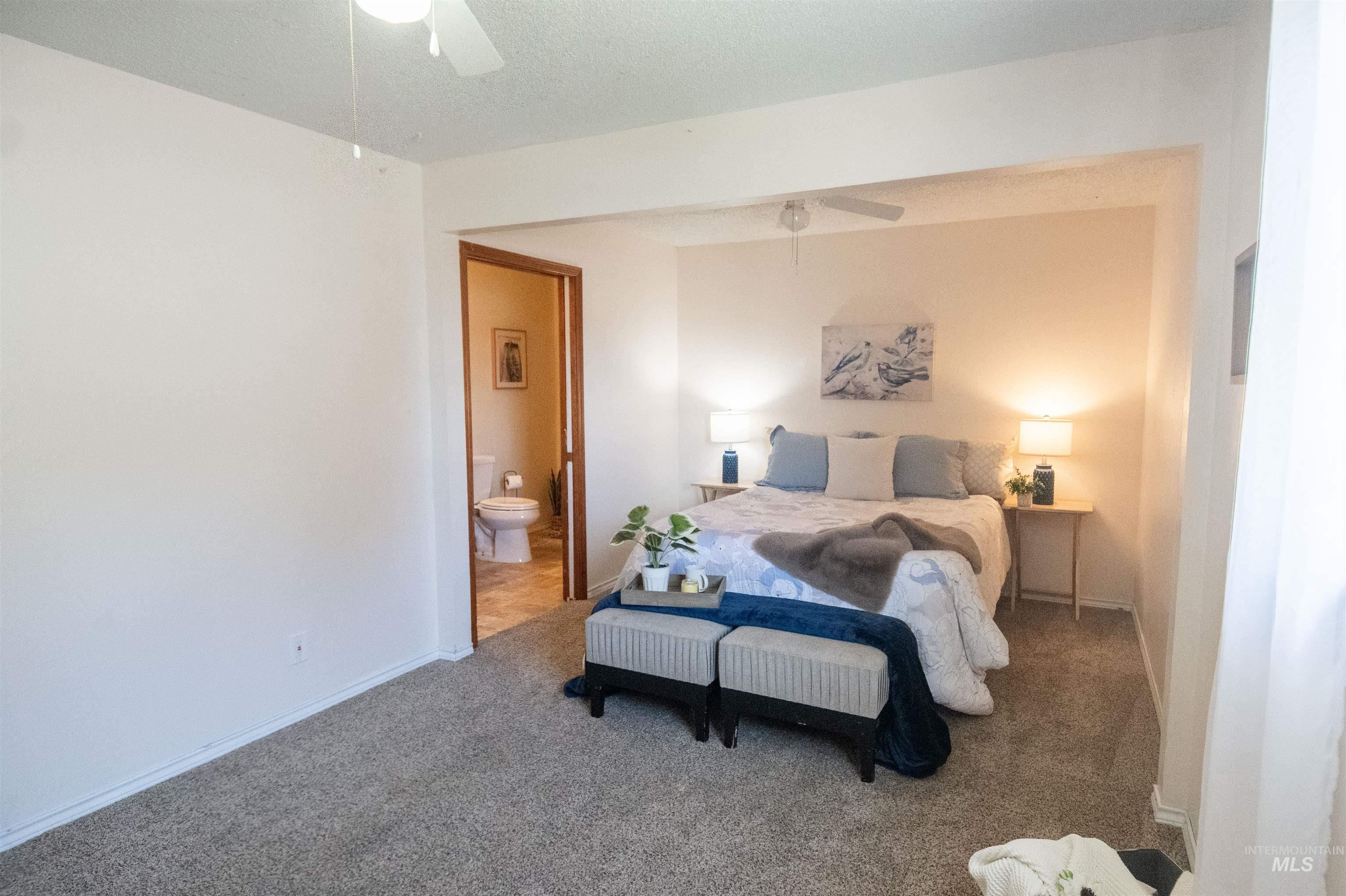 Bedroom featuring carpet floors, ensuite bath, and ceiling fan