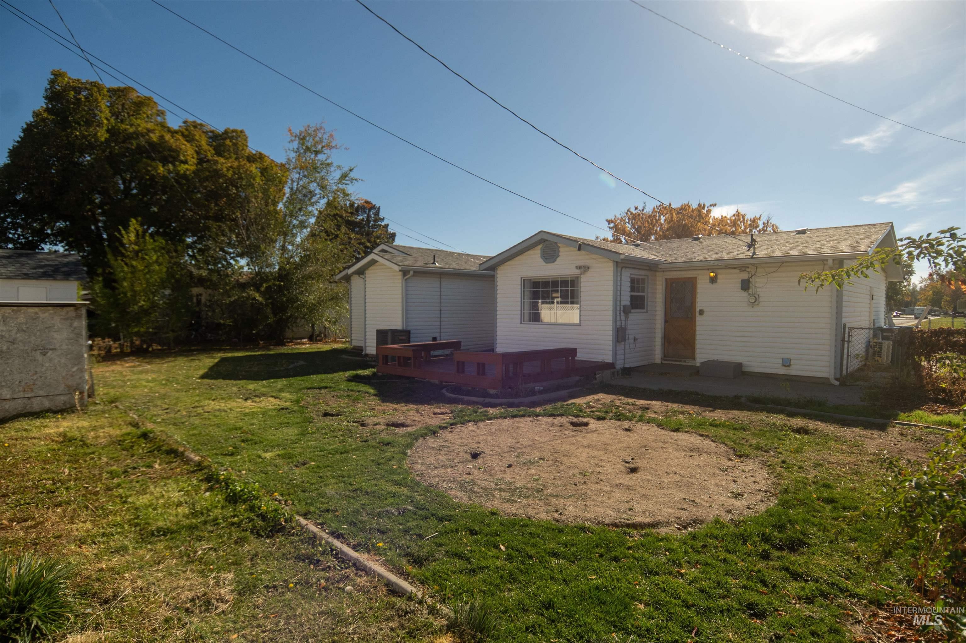 View of front of property featuring a front lawn, a patio, and a deck