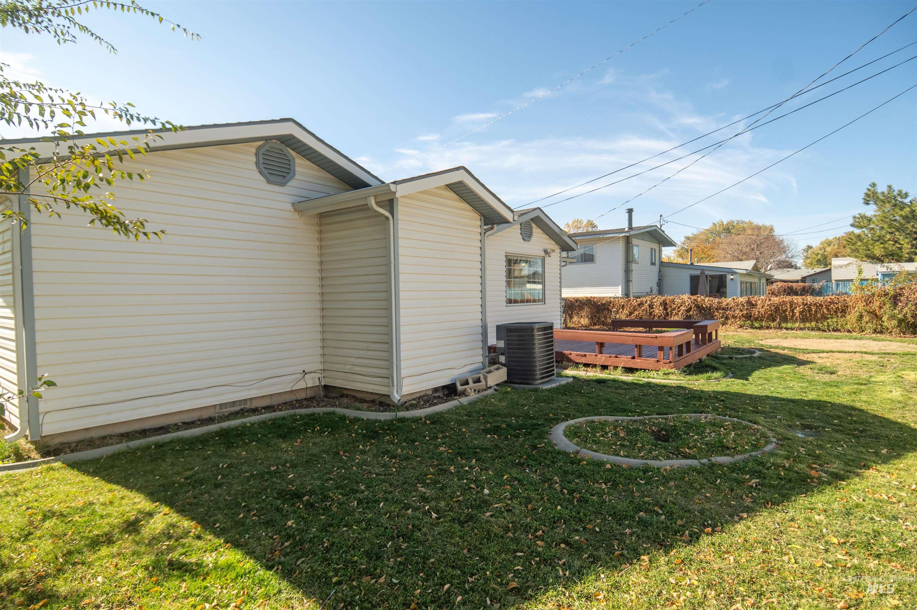 View of home's exterior with a lawn and a deck