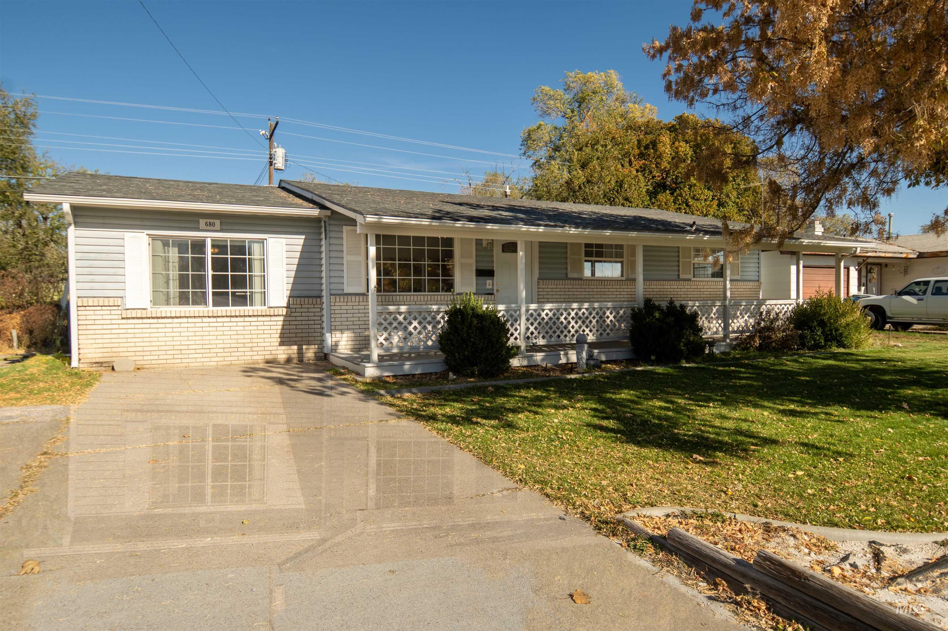 Ranch-style home featuring brick siding, a front yard, and a porch