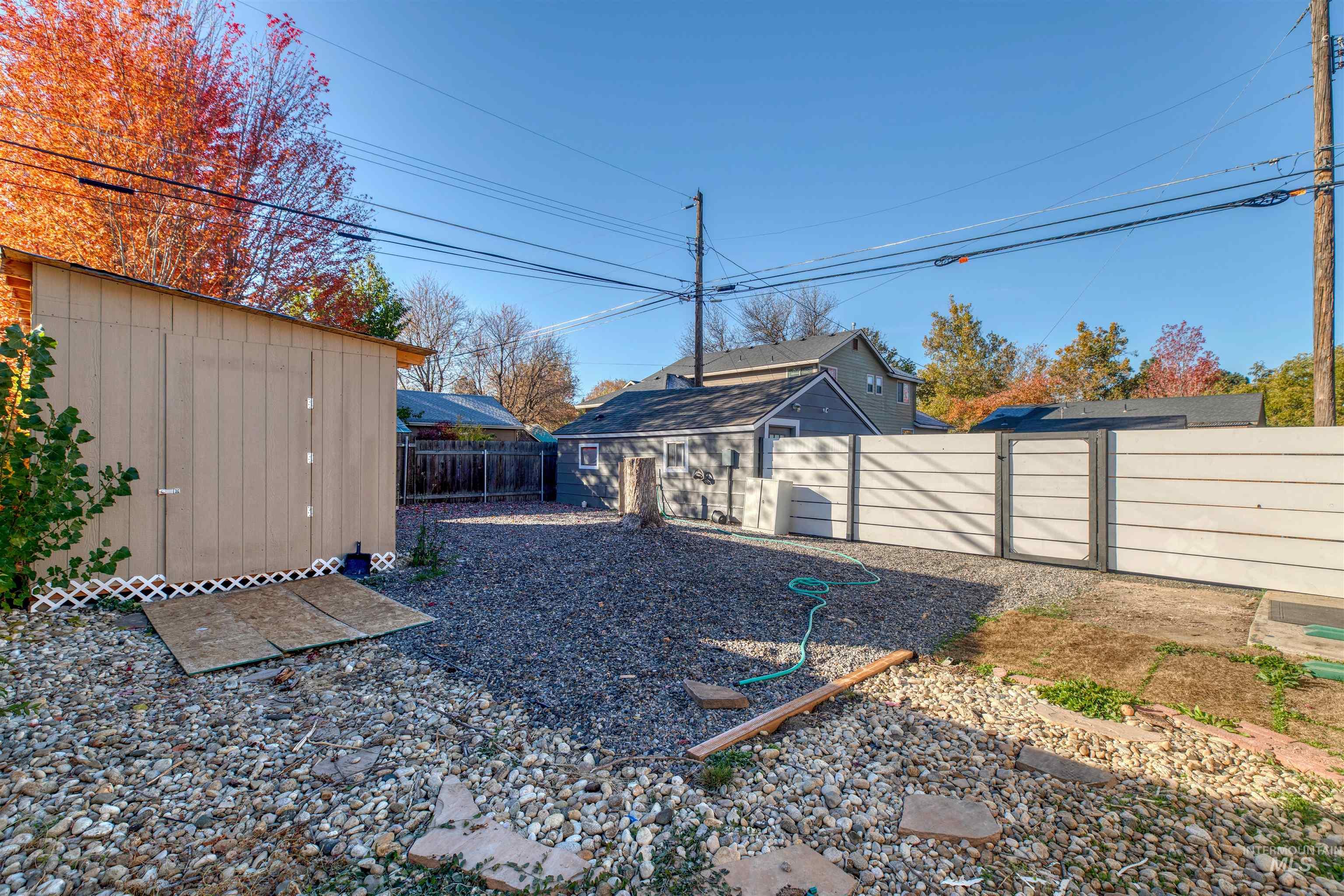 Fenced backyard featuring a shed and a gate