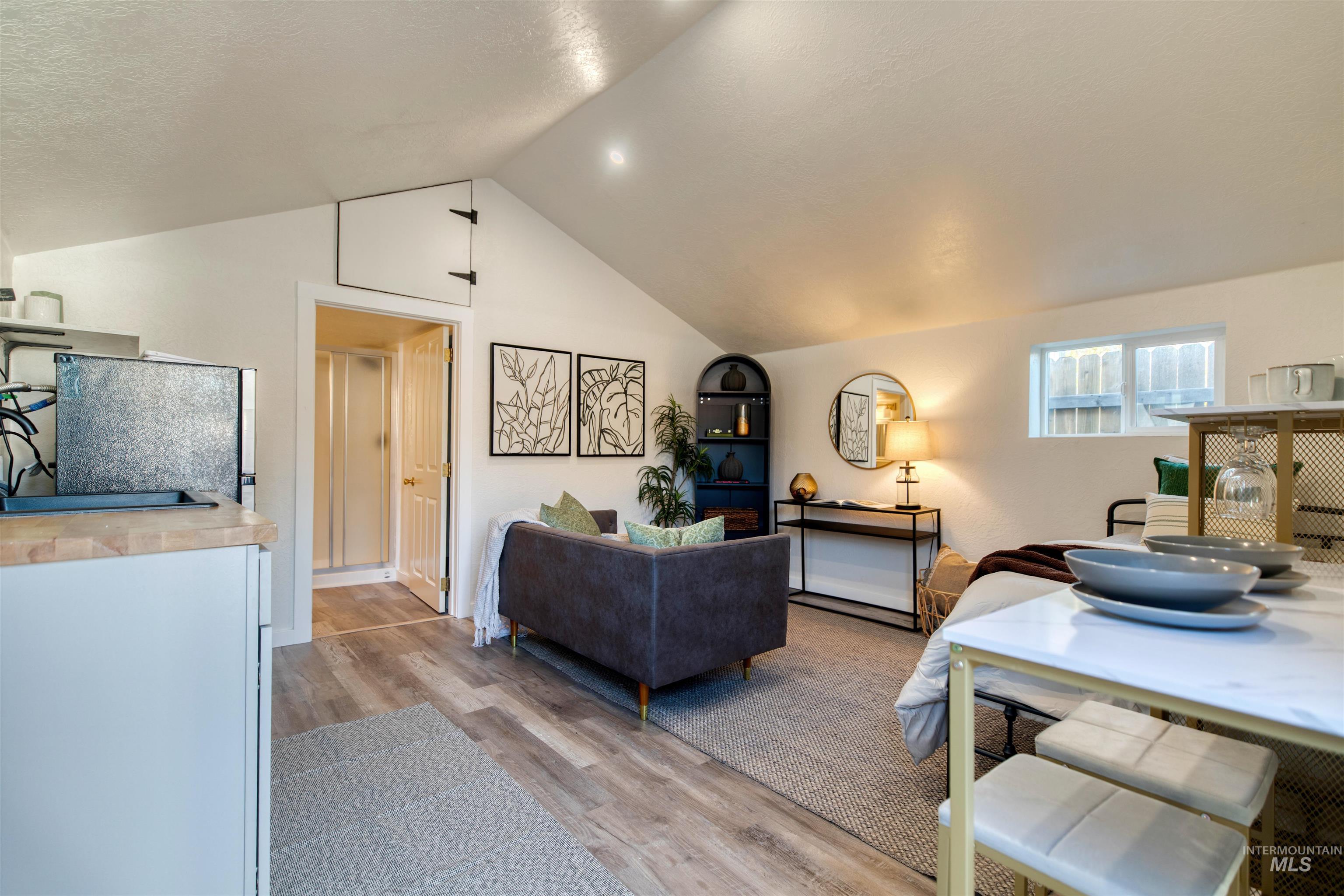 Living area with light wood finished floors and lofted ceiling