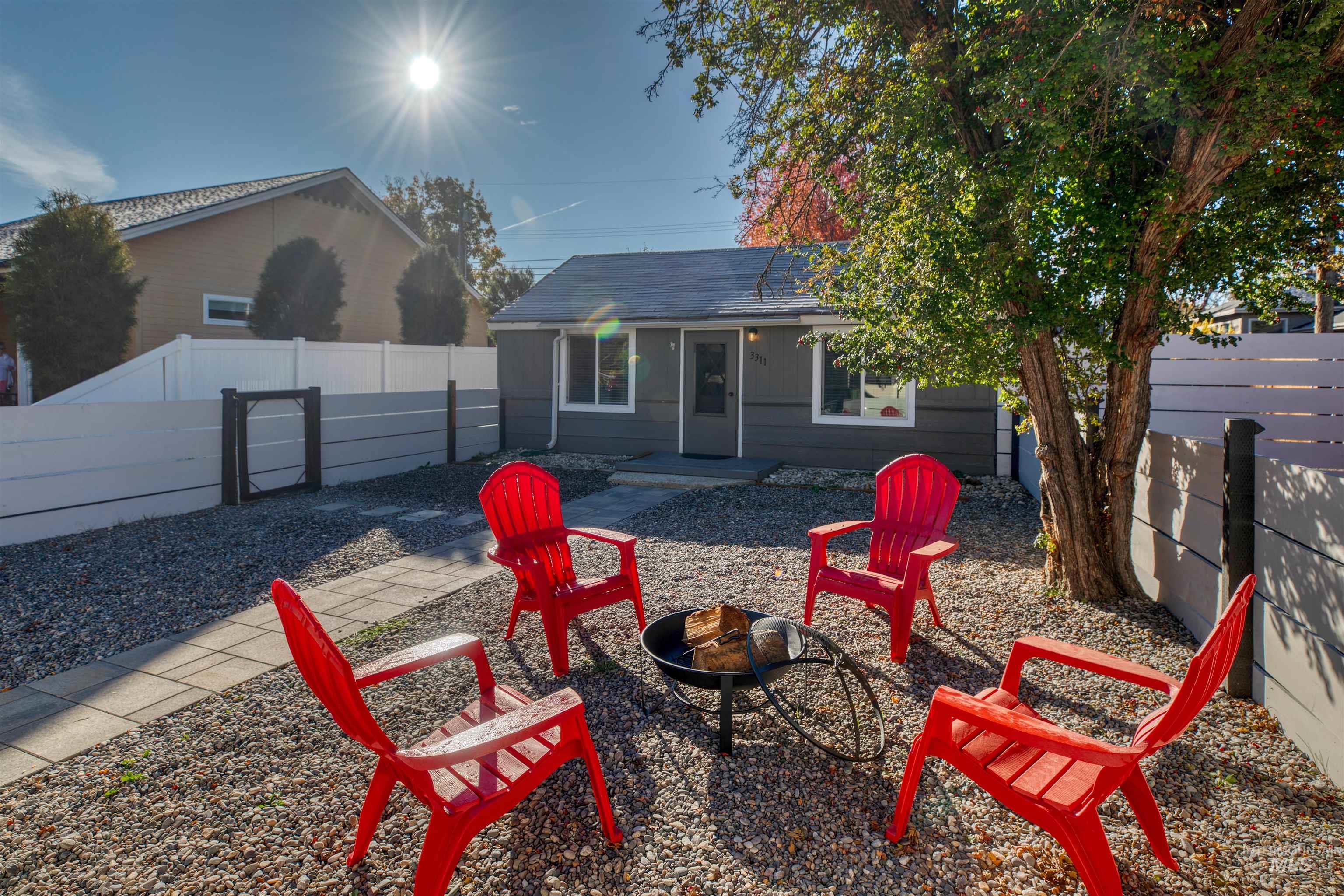 Rear view of property featuring a fenced backyard, a fire pit, and a patio area