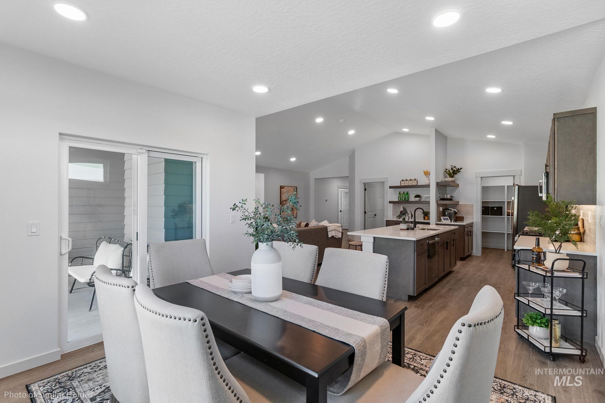 Dining room featuring light wood-type flooring, vaulted ceiling, and recessed lighting