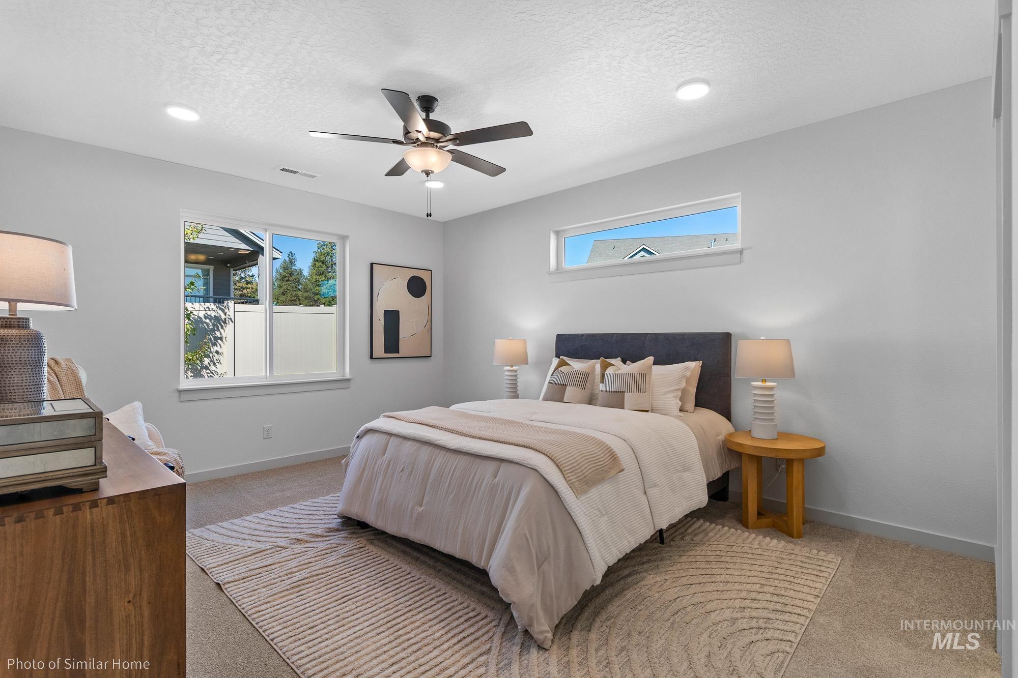 Carpeted bedroom with a textured ceiling and a ceiling fan