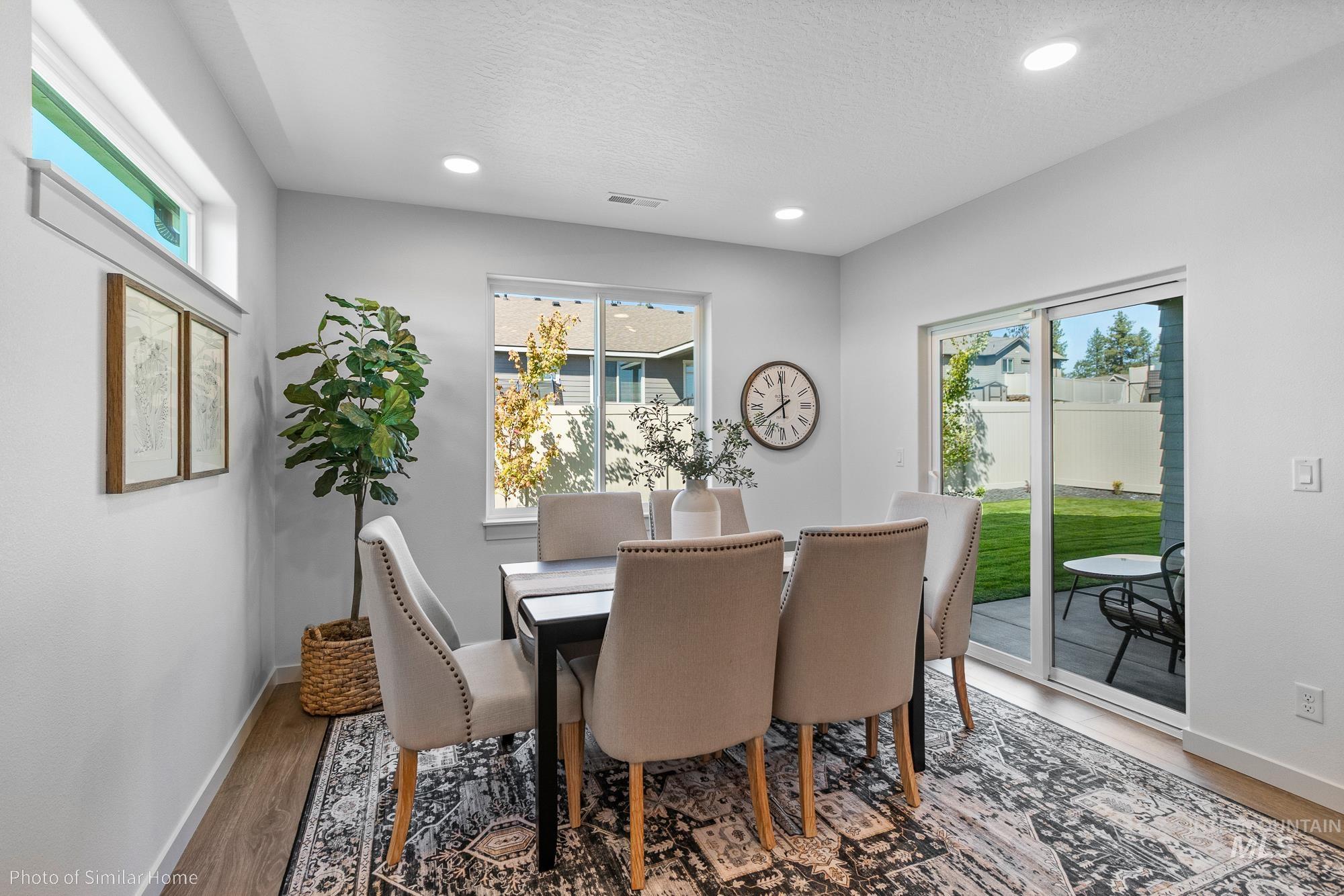 Dining space with plenty of natural light, recessed lighting, light wood-style floors, and a textured ceiling