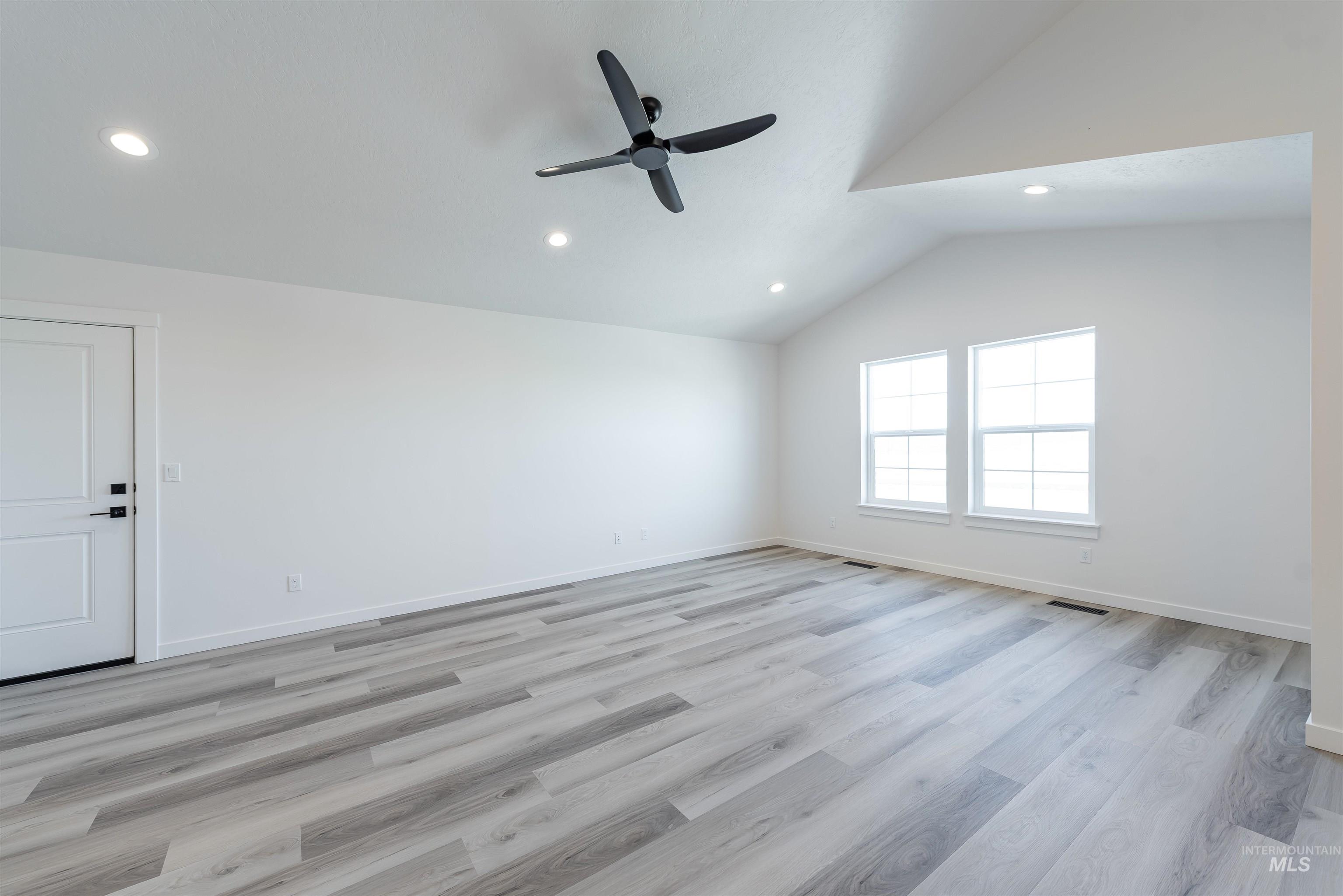 Unfurnished room with vaulted ceiling, light wood-style flooring, recessed lighting, and ceiling fan