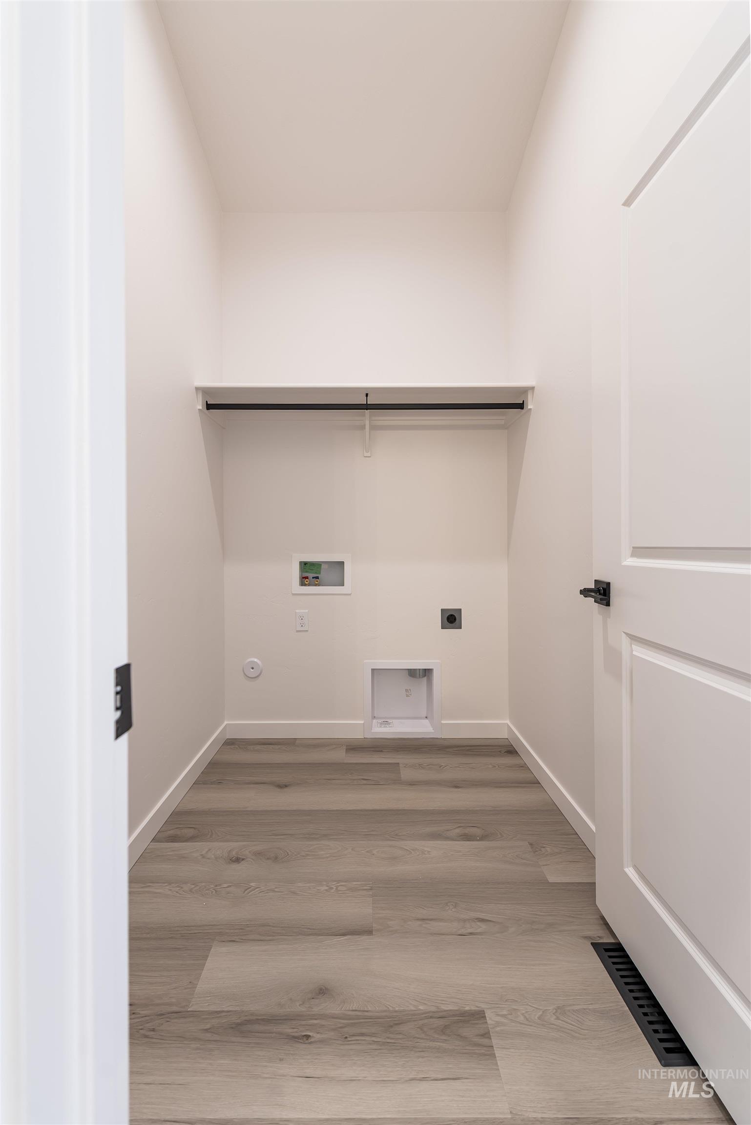 Laundry room featuring light wood finished floors, hookup for an electric dryer, and hookup for a washing machine