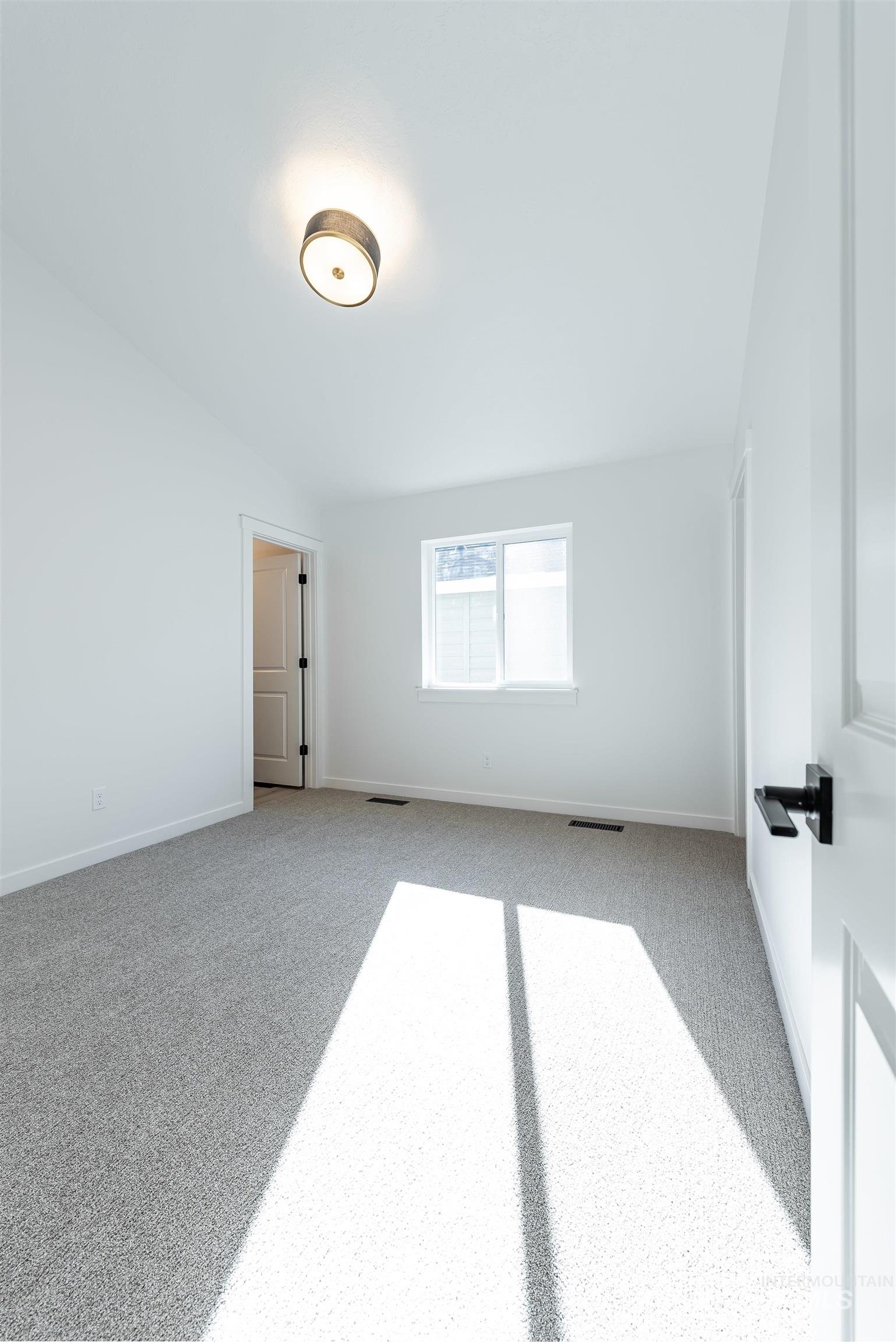 Spare room featuring carpet floors and baseboards