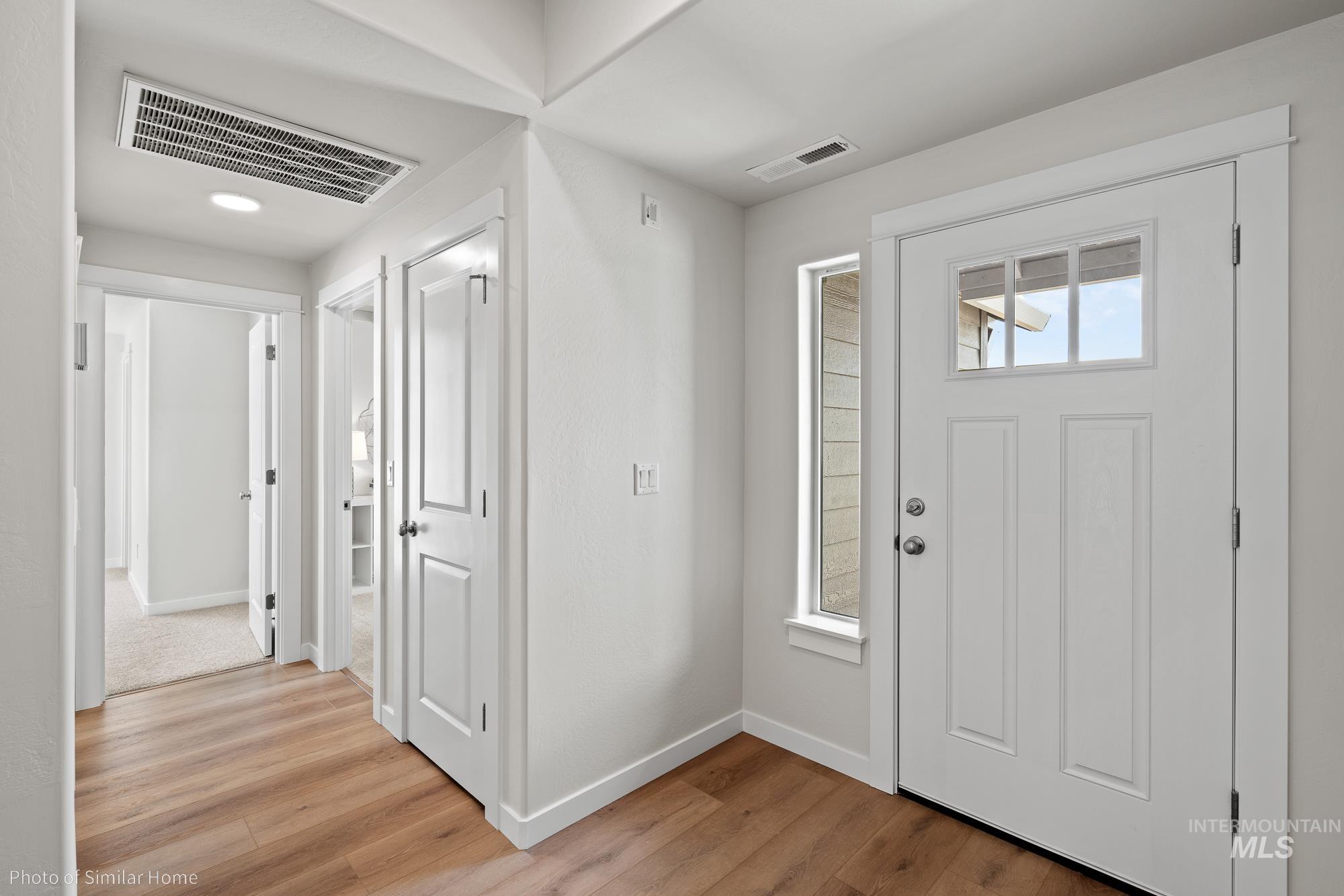 Foyer with light wood-style flooring and baseboards