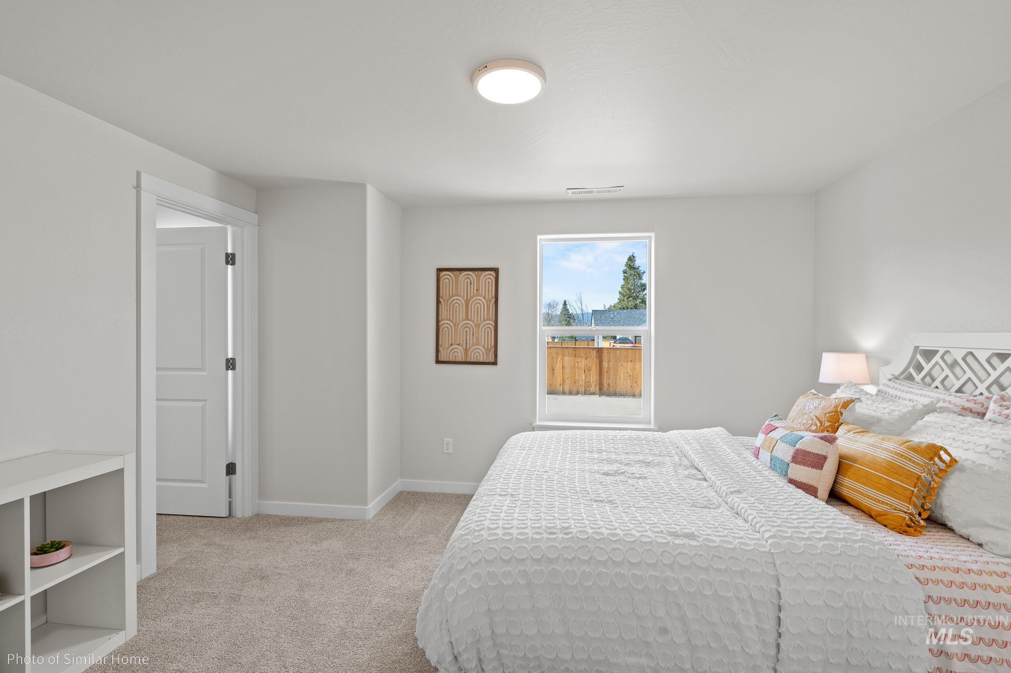 Bedroom with light carpet and baseboards