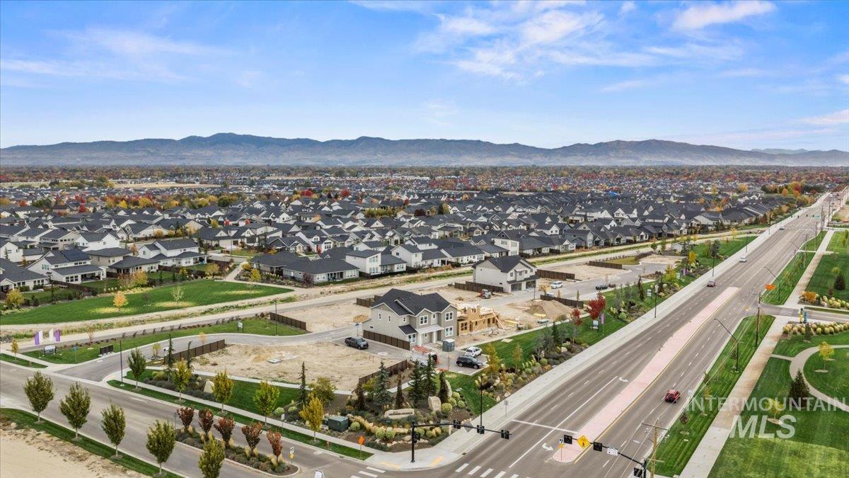 Aerial view of property and surrounding area with nearby suburban area and a mountain backdrop