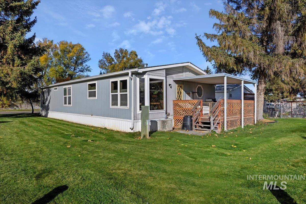 Rear view of house with a lawn and a deck