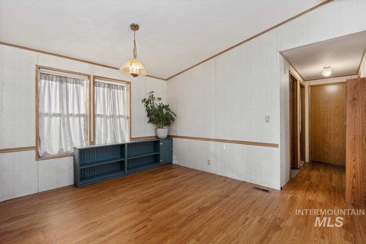 Spare room with wood finished floors and ornamental molding