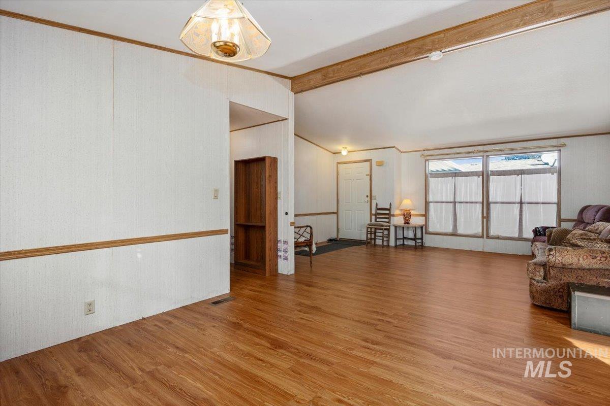 Living room with wood finished floors and crown molding