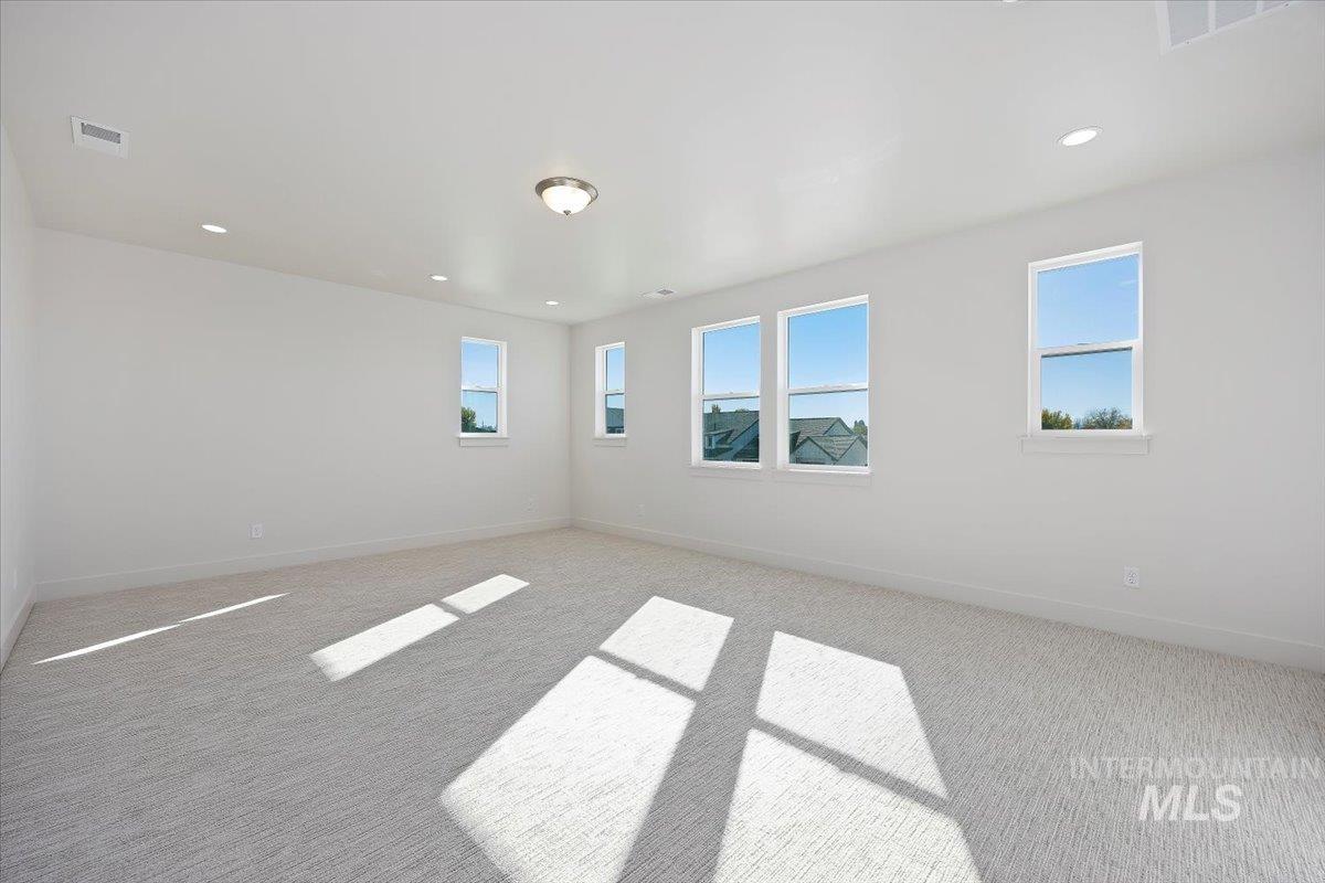 Carpeted empty room featuring baseboards and recessed lighting