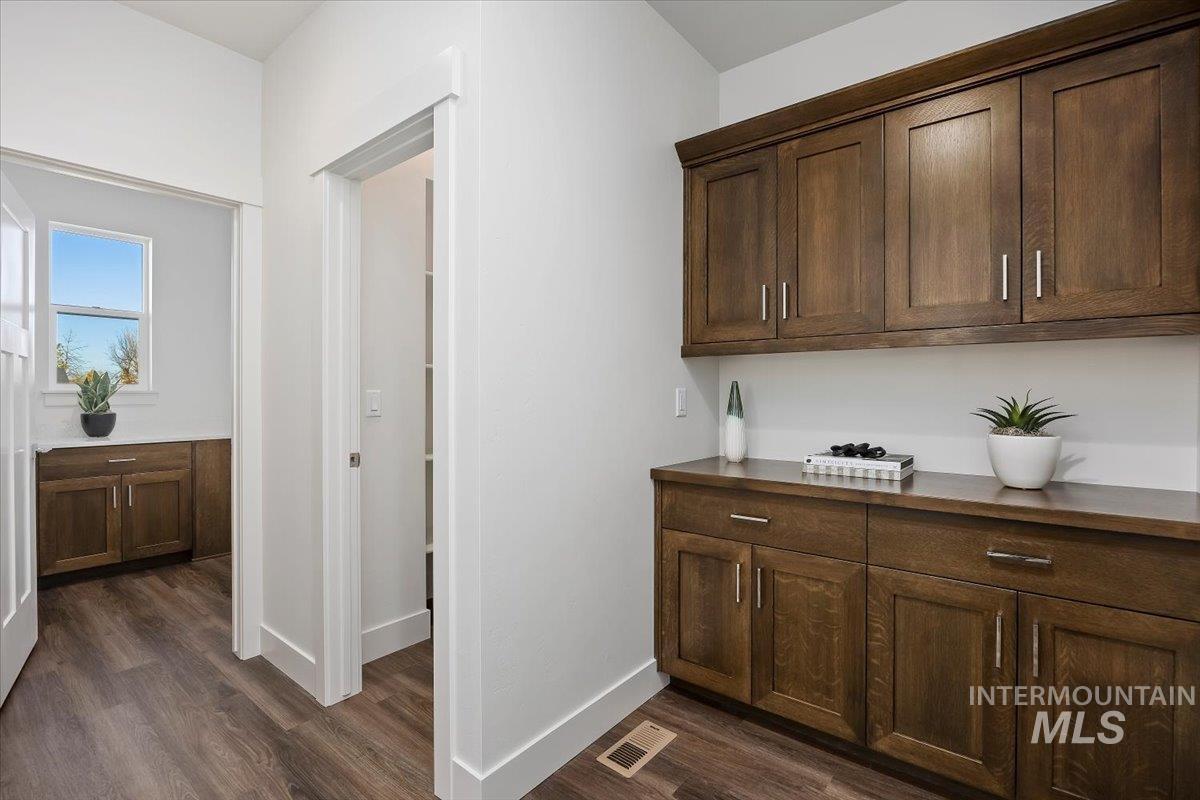 Hallway featuring baseboards and dark wood-style flooring