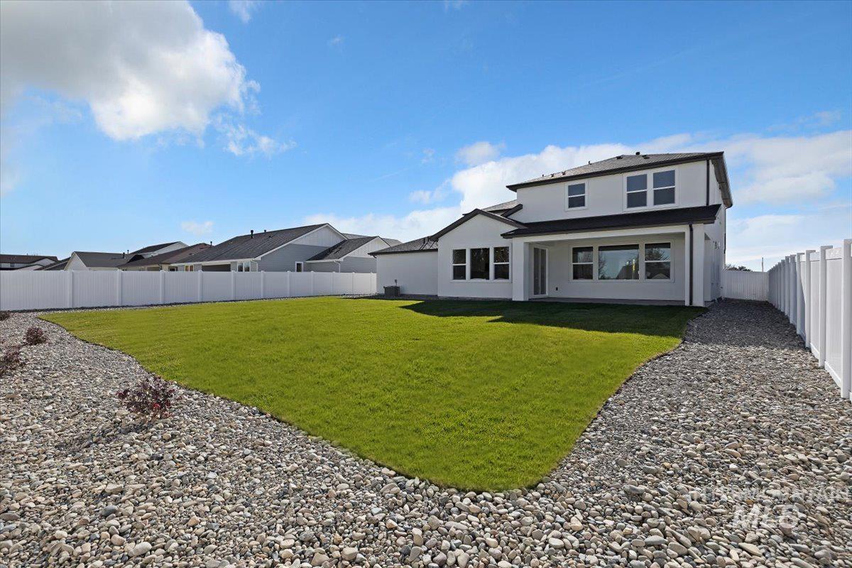 Rear view of house featuring a fenced backyard, stucco siding, a residential view, and a patio