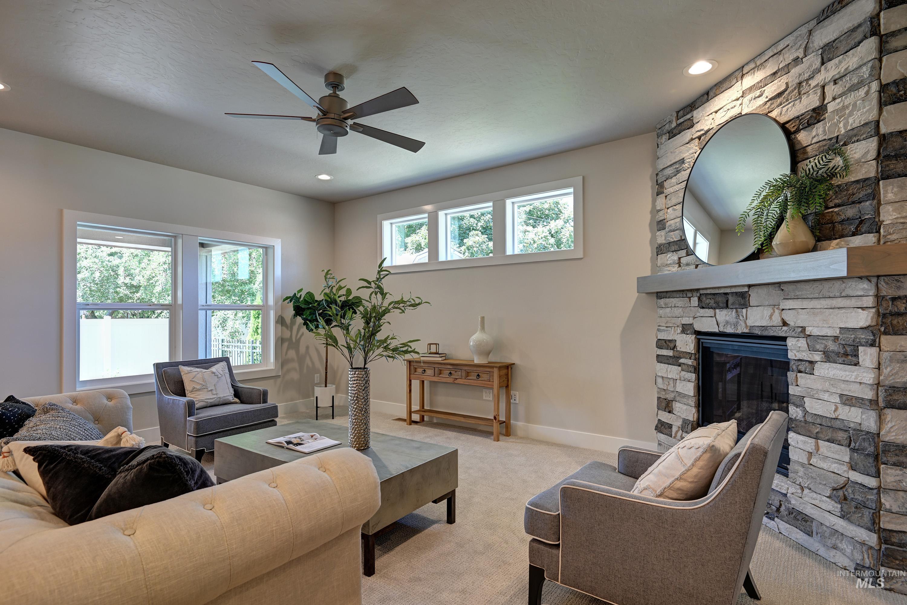 Living area with a ceiling fan, light carpet, a fireplace, and recessed lighting