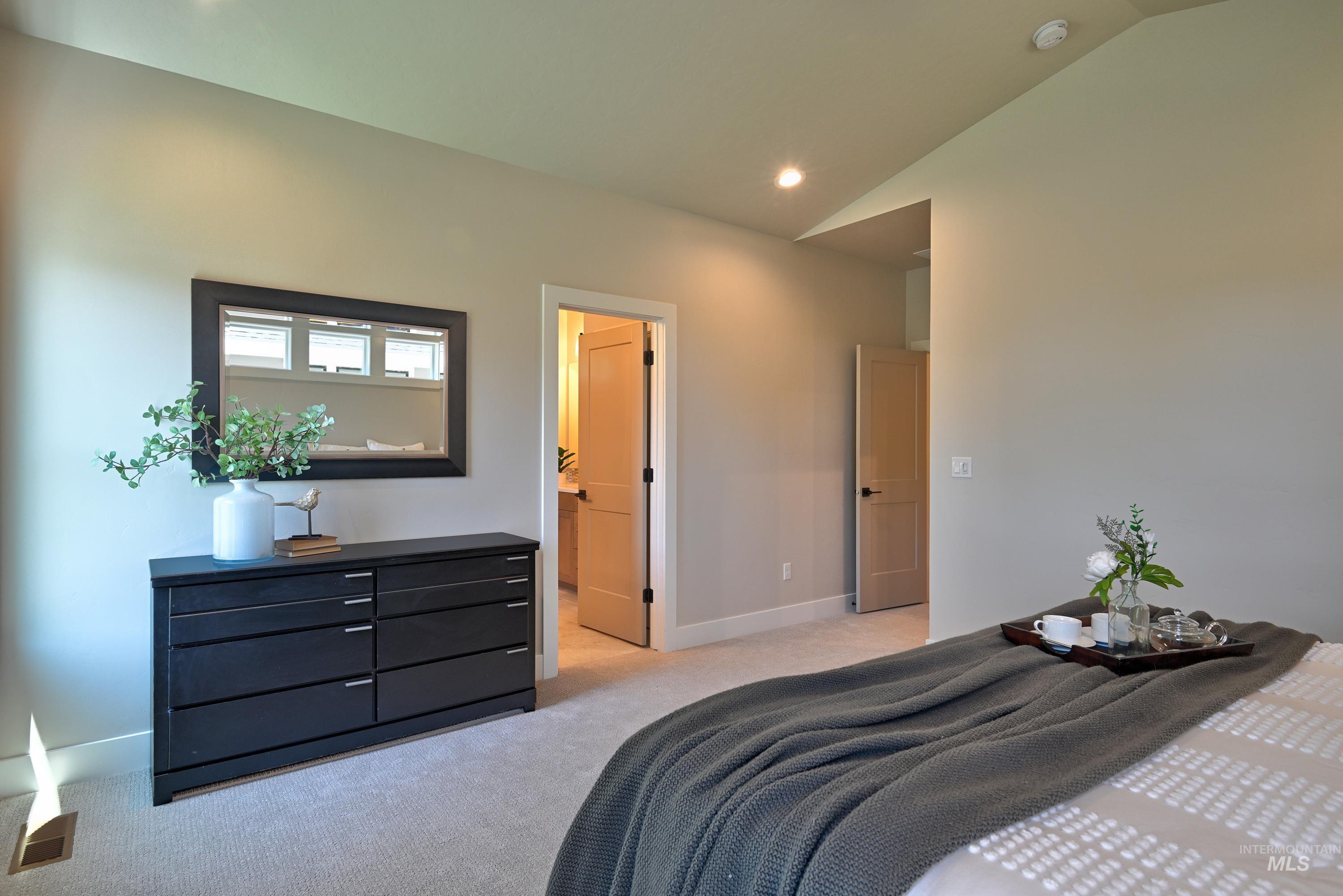 Bedroom with light carpet, vaulted ceiling, and recessed lighting