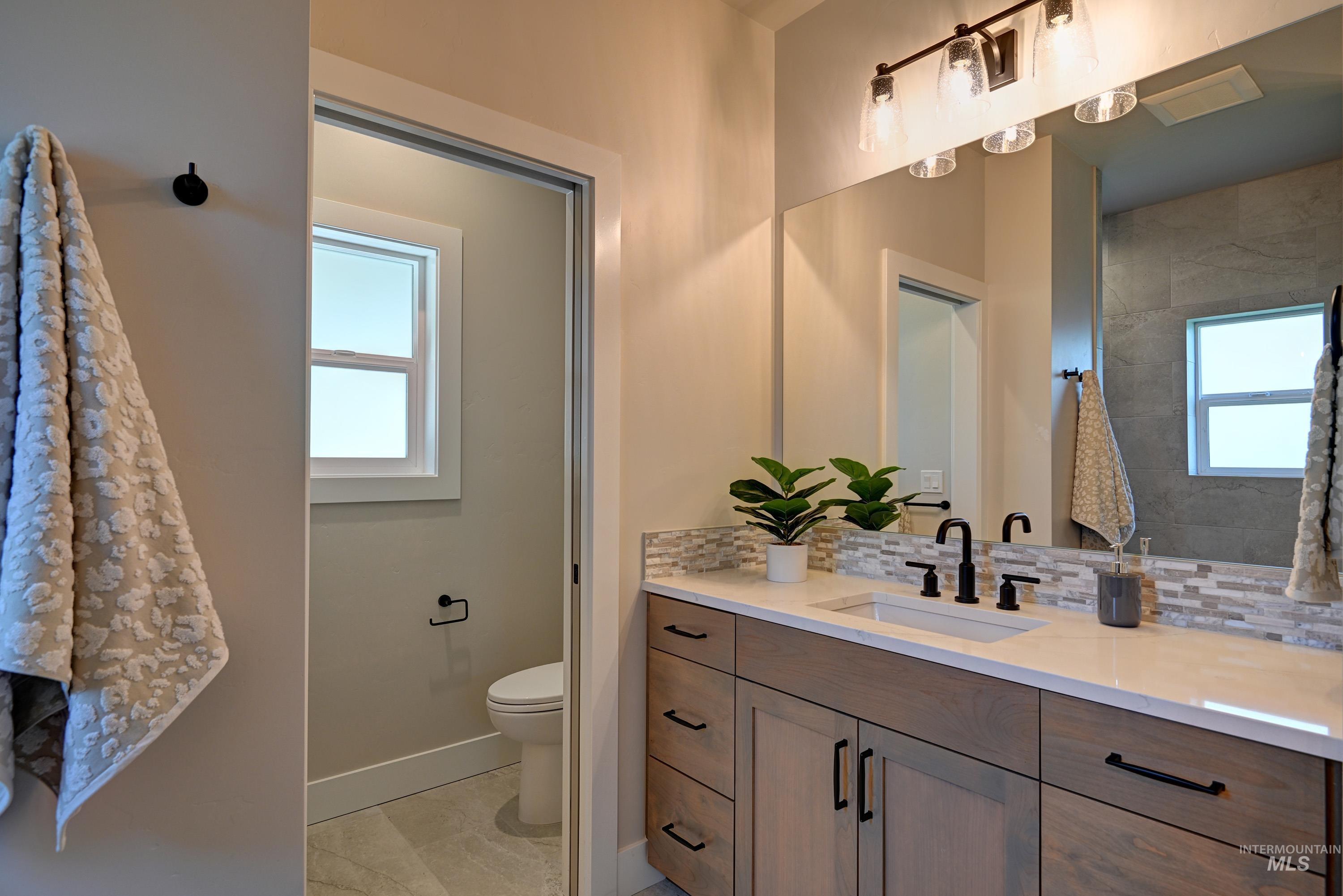 Full bathroom featuring vanity, backsplash, healthy amount of natural light, and Tile finish floors