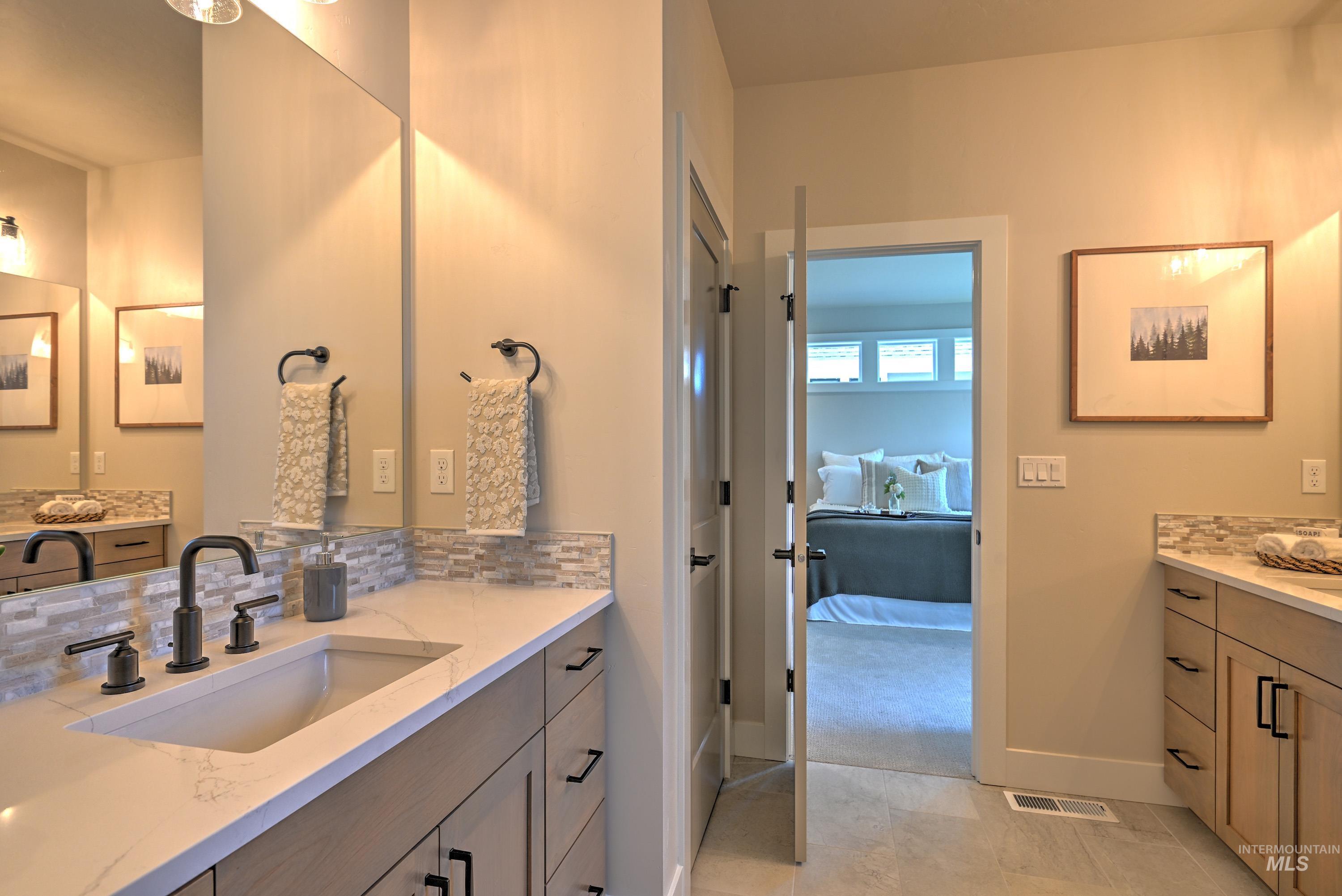 Ensuite bathroom with two vanities and decorative backsplash