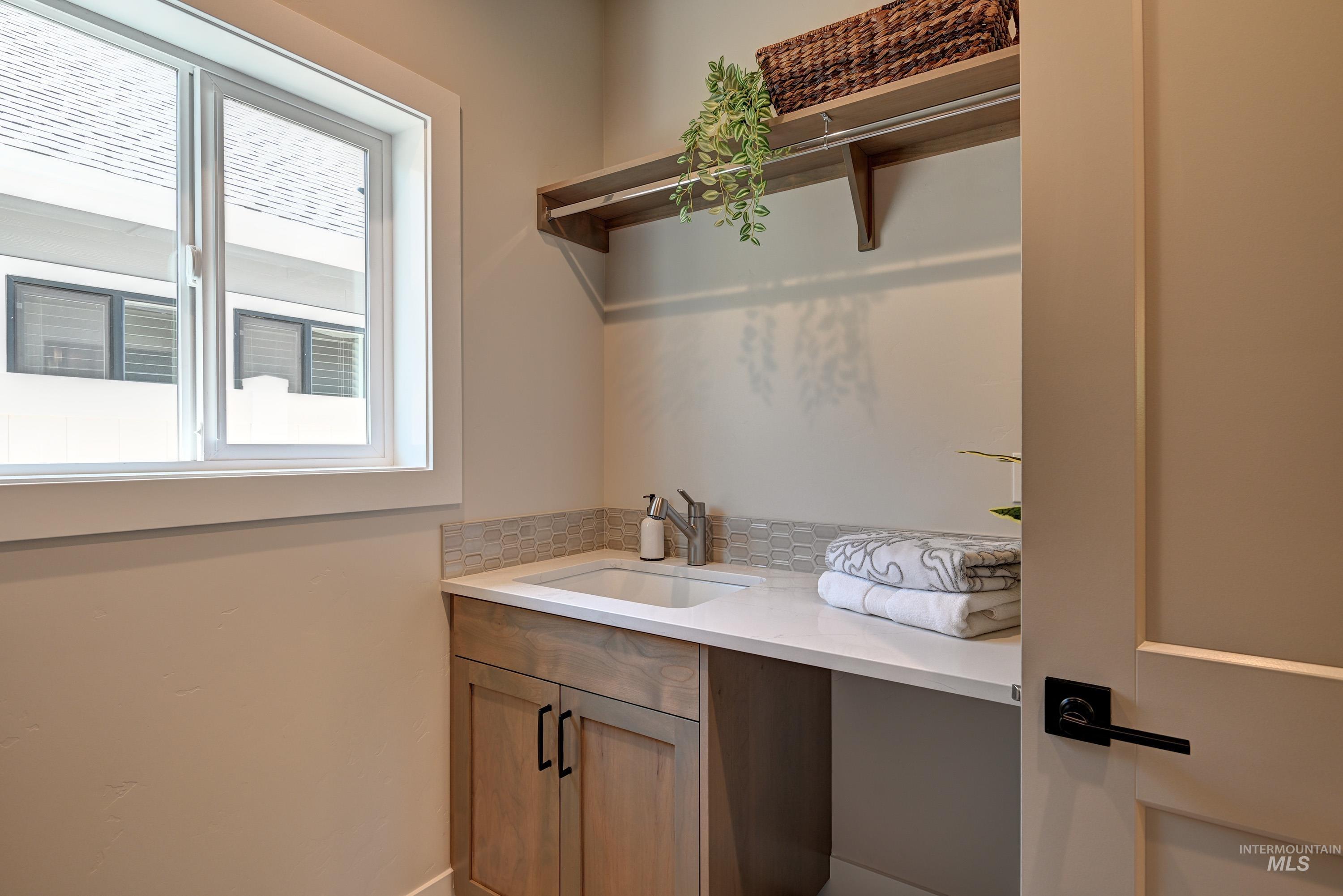 Laundry room featuring a sink and baseboards