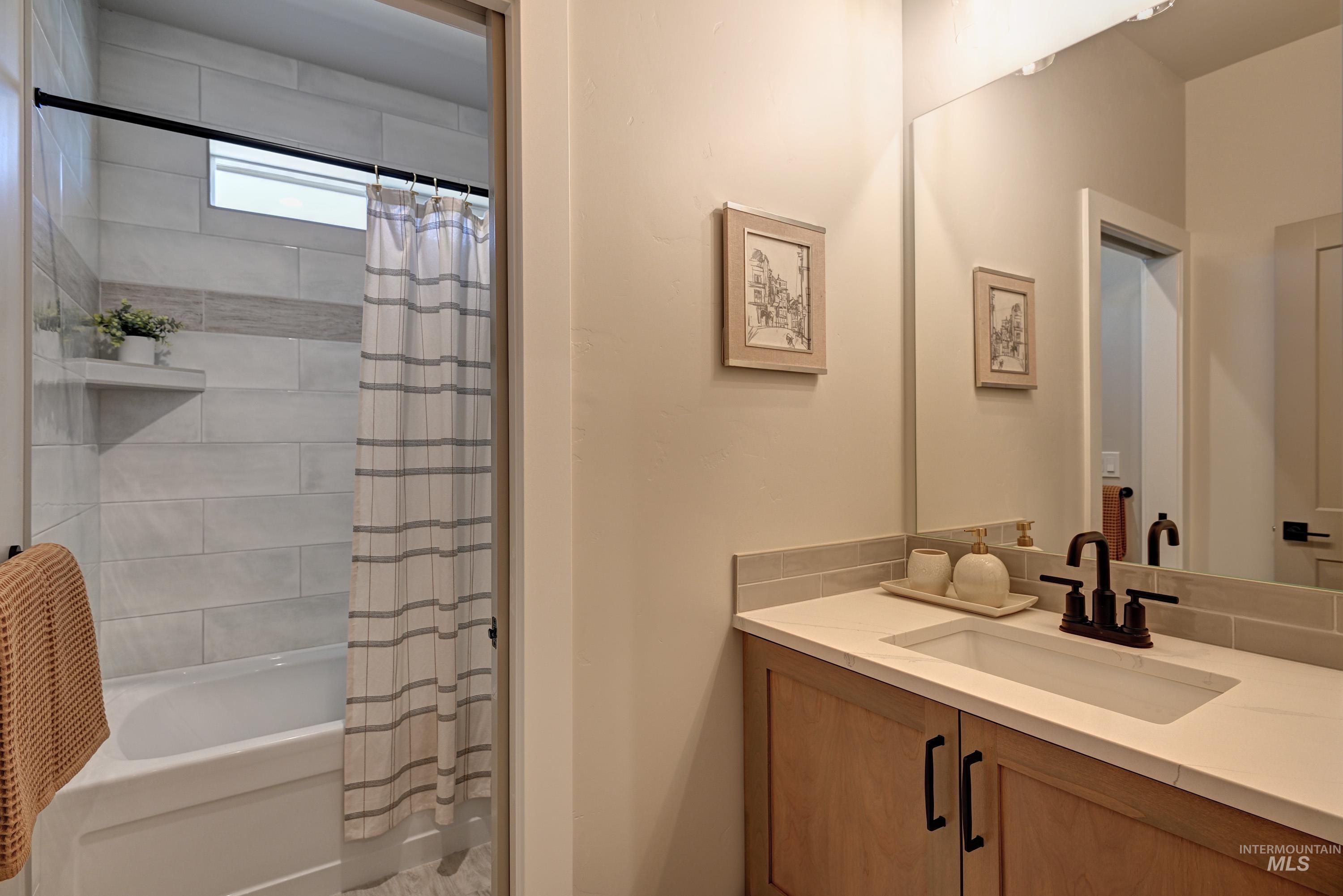 Bathroom featuring vanity and shower / tub combo with curtain
