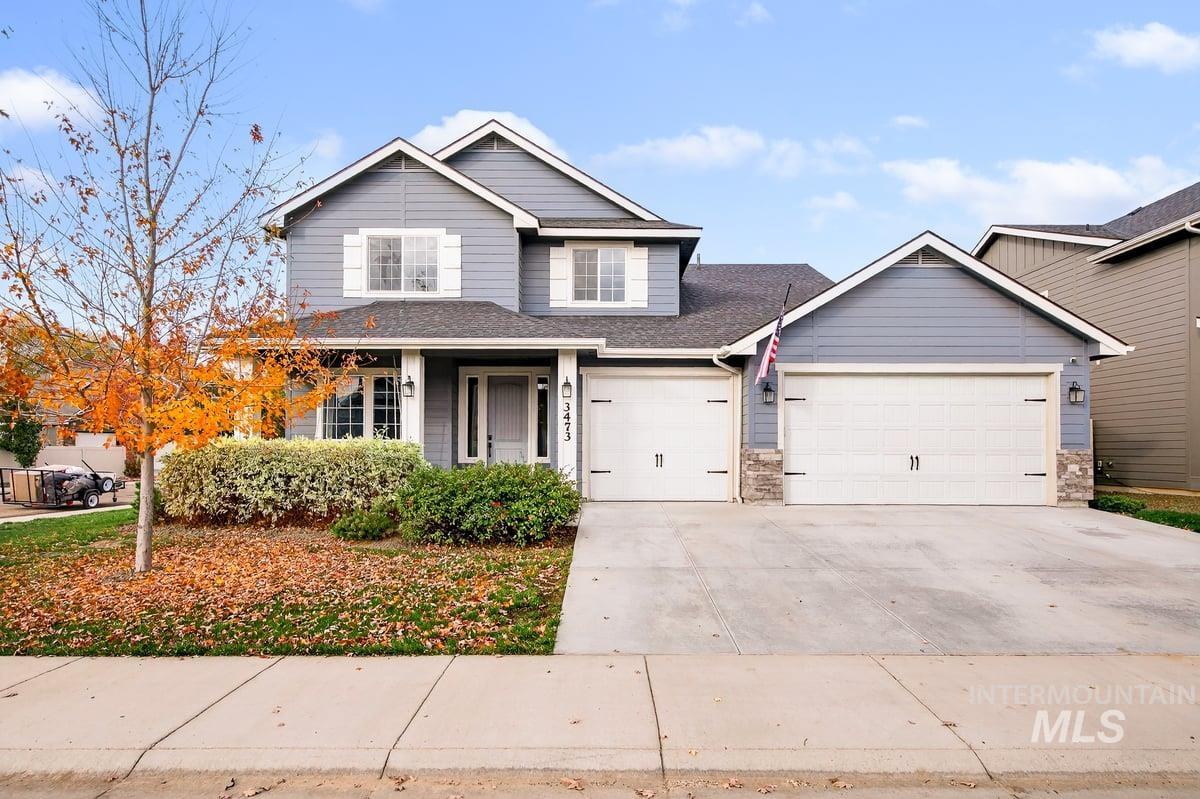 Traditional-style home featuring concrete driveway, a shingled roof, an attached garage, and a porch