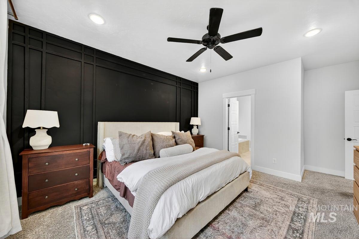 Bedroom with light carpet, ceiling fan, ensuite bathroom, and recessed lighting