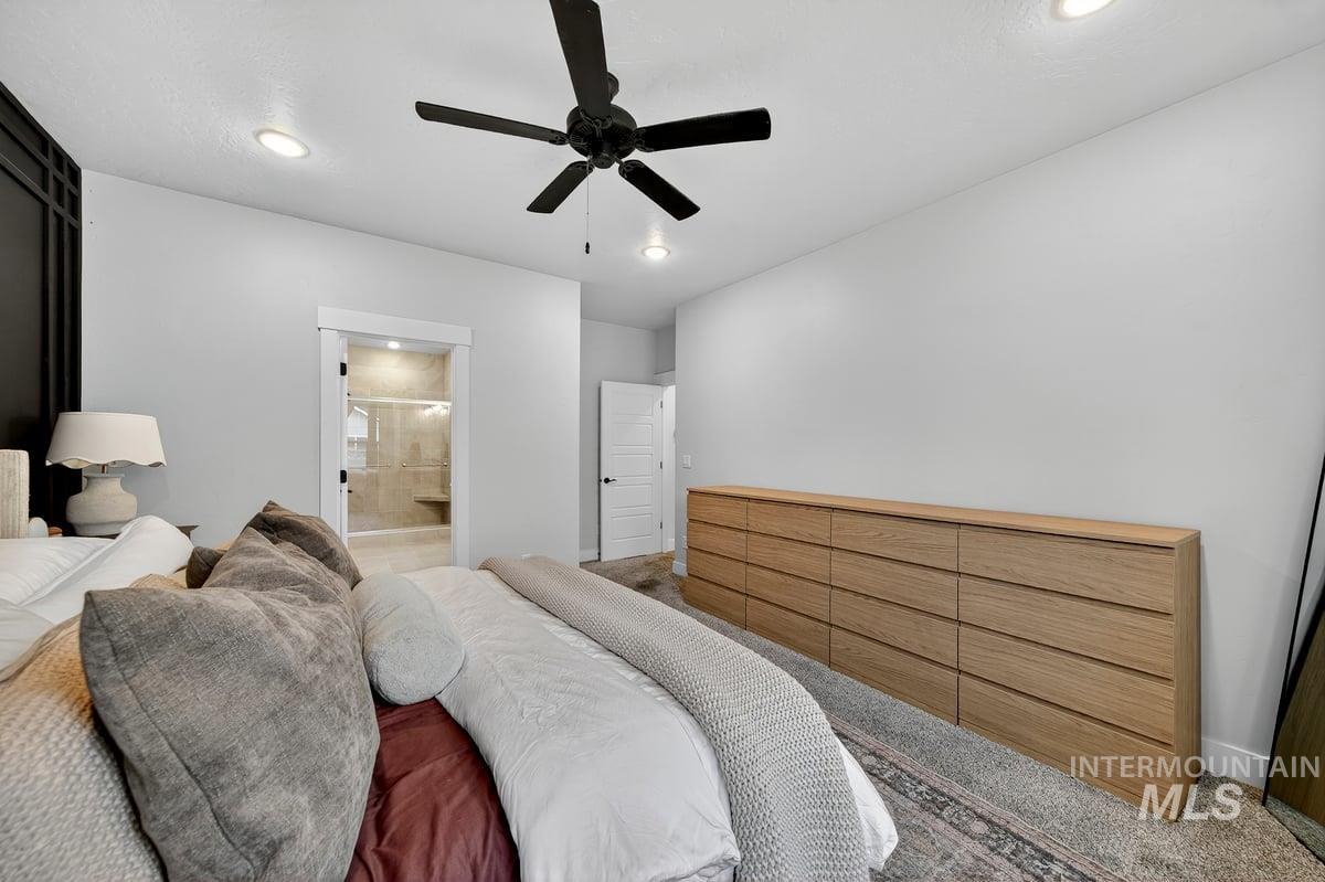Carpeted bedroom with ceiling fan, connected bathroom, and recessed lighting