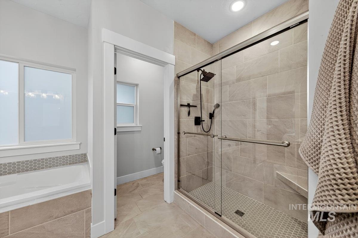 Bathroom with a stall shower, a bath, and recessed lighting