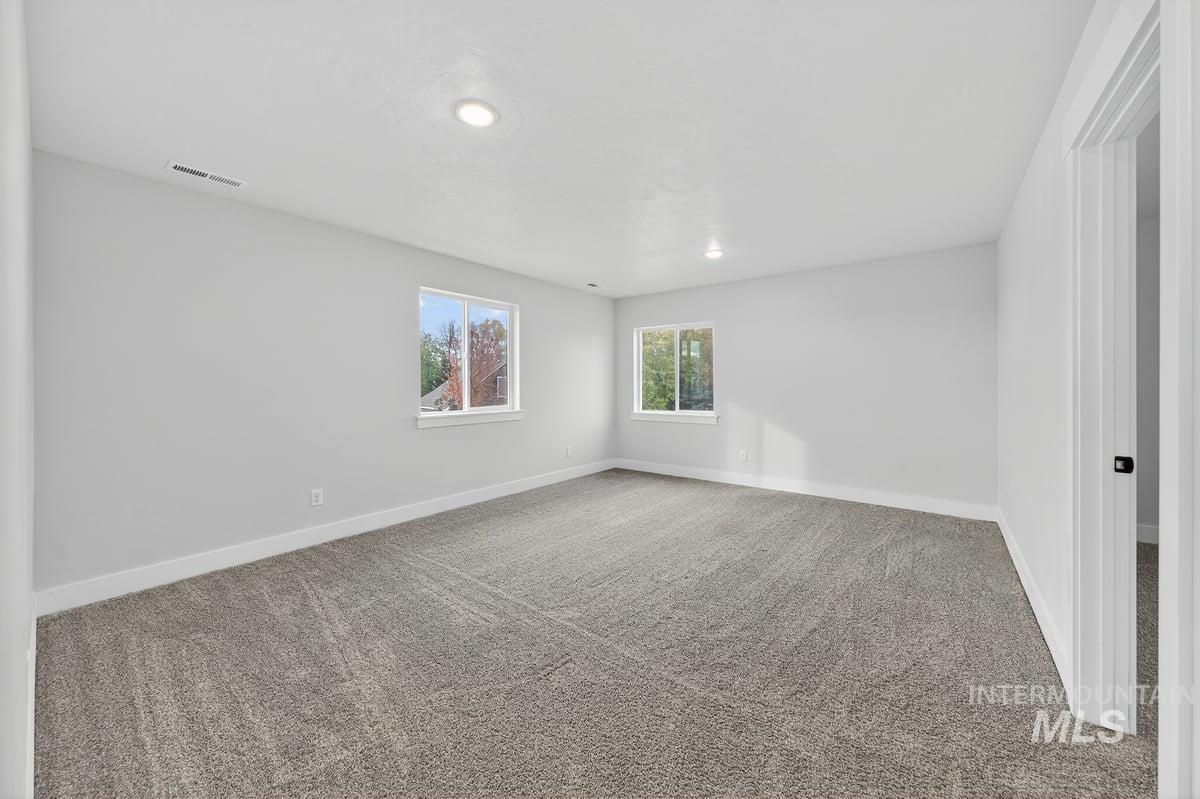 Carpeted empty room featuring recessed lighting