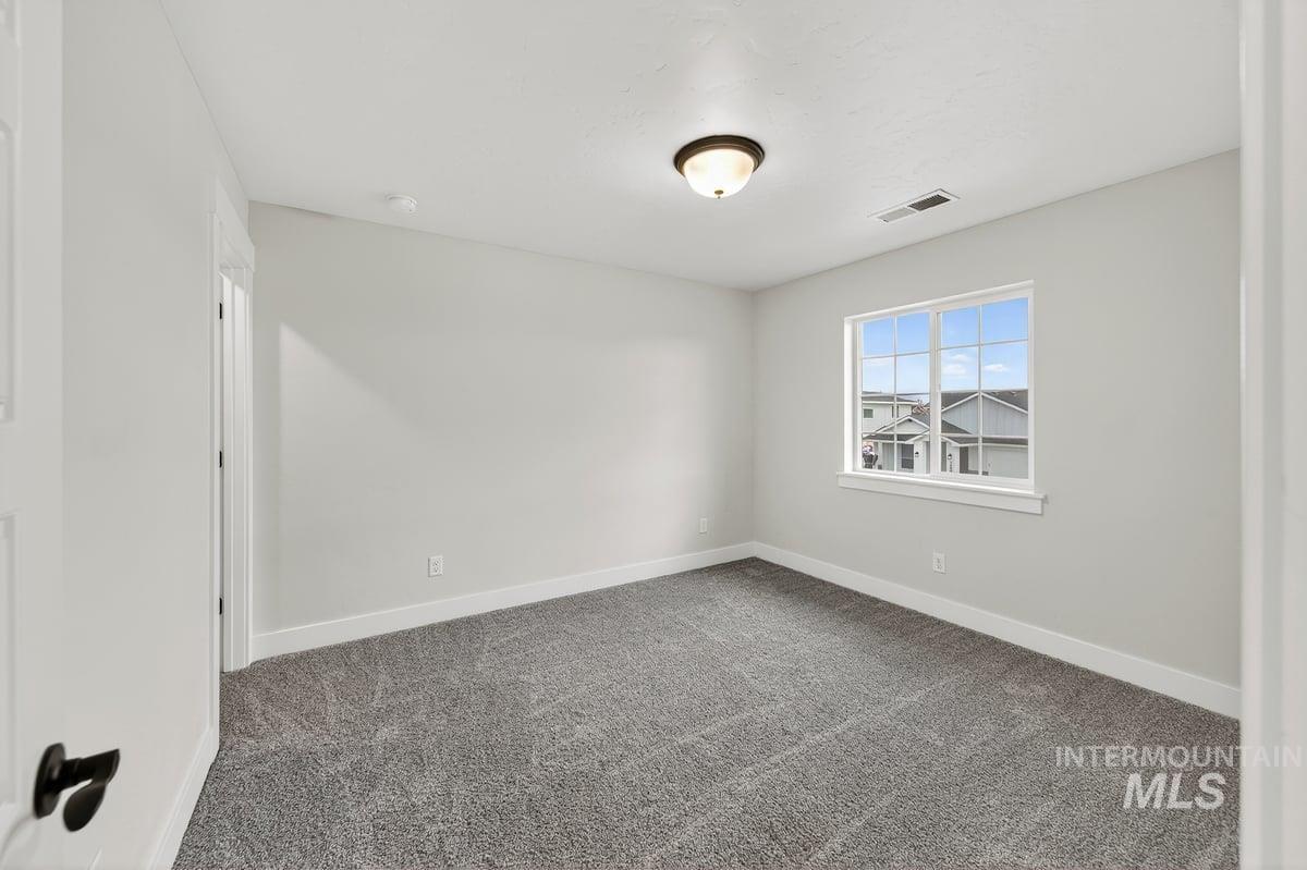 Empty room featuring carpet and baseboards