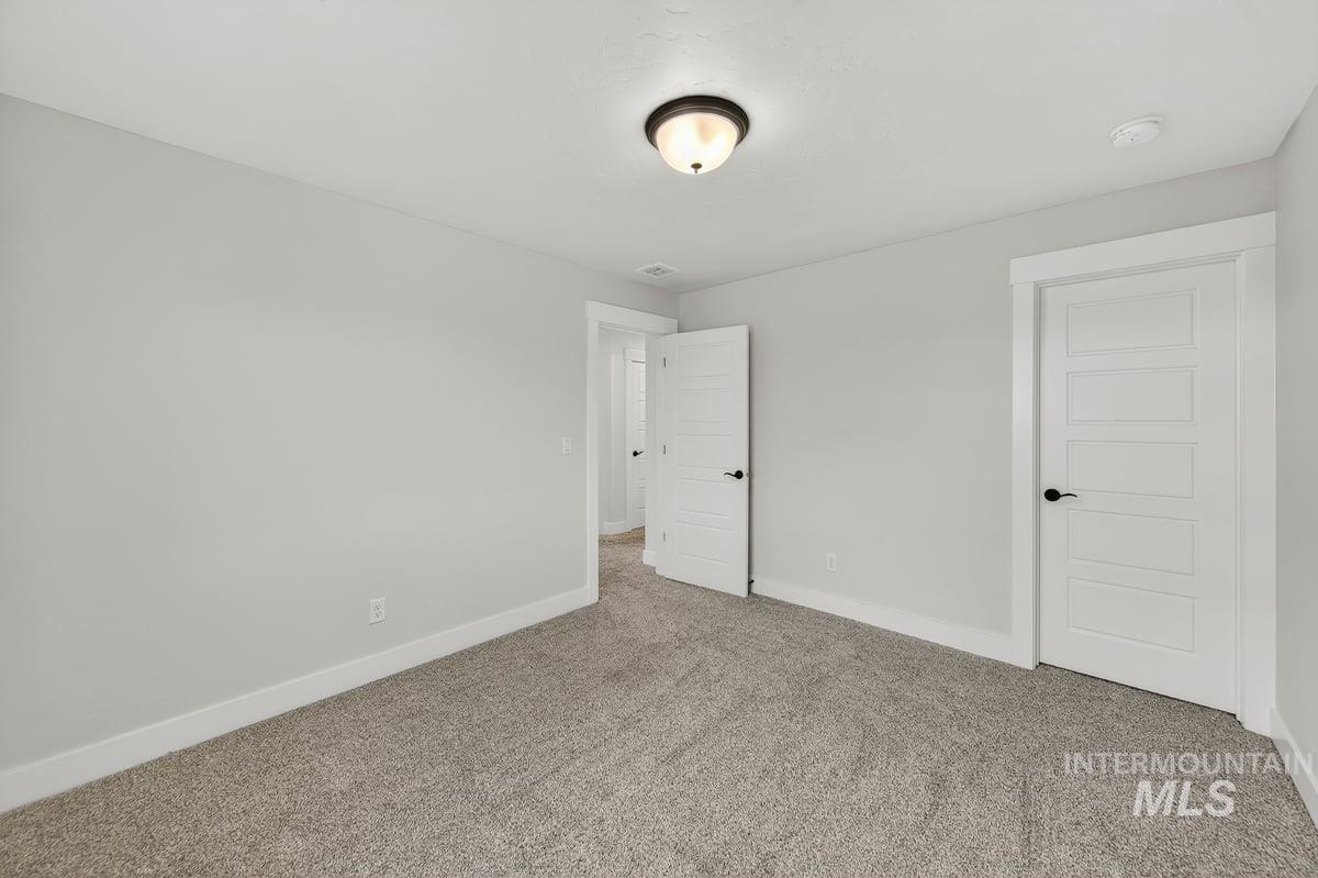 Unfurnished bedroom with baseboards and carpet