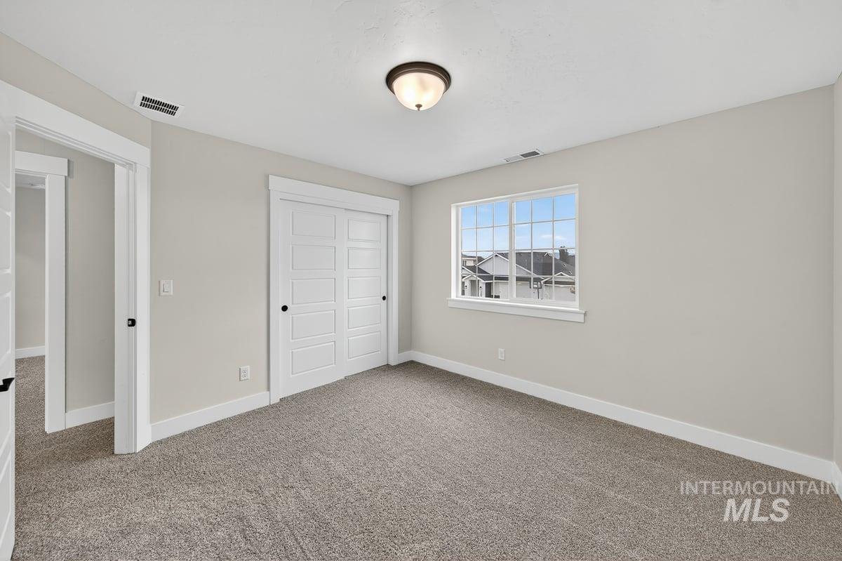 Unfurnished bedroom featuring light carpet and a closet