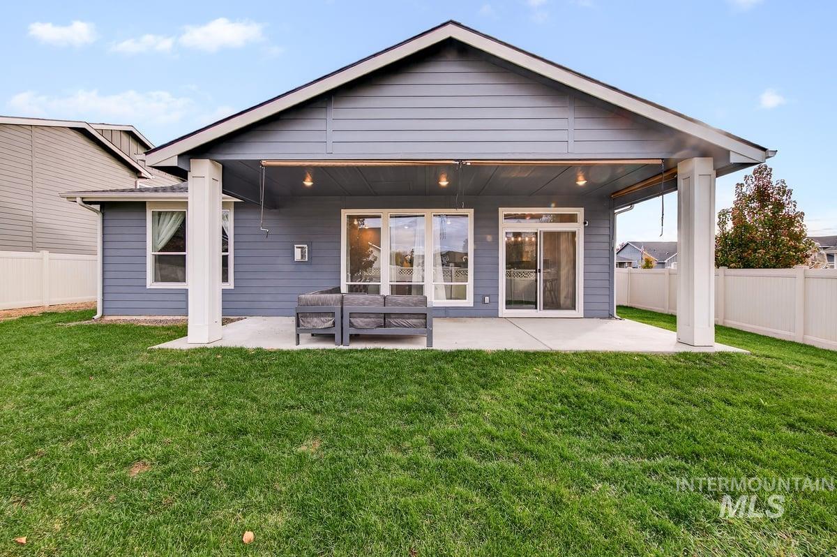 Rear view of house featuring a fenced backyard and a patio