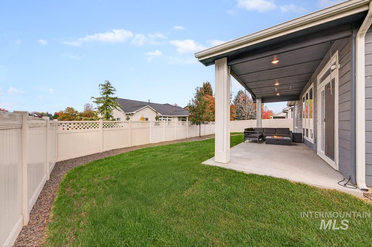 Fenced backyard featuring a patio area and an outdoor hangout area