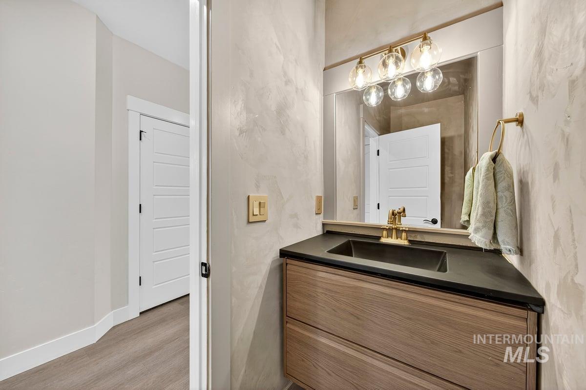 Half bath featuring vanity and light wood-type flooring