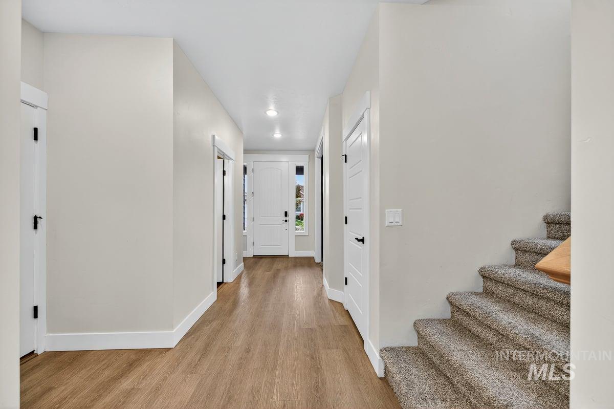 Corridor featuring light wood finished floors and stairs