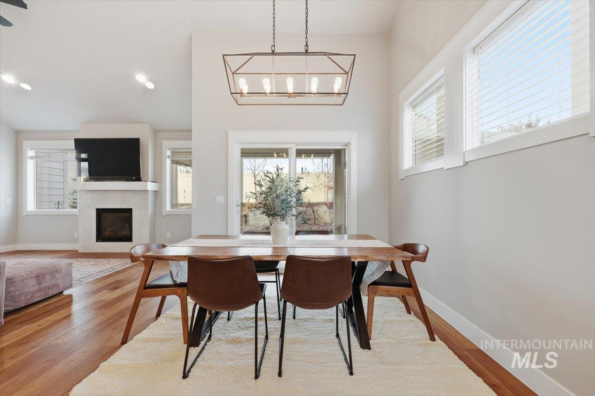 Dining space featuring light wood-type flooring, a tiled fireplace, and recessed lighting