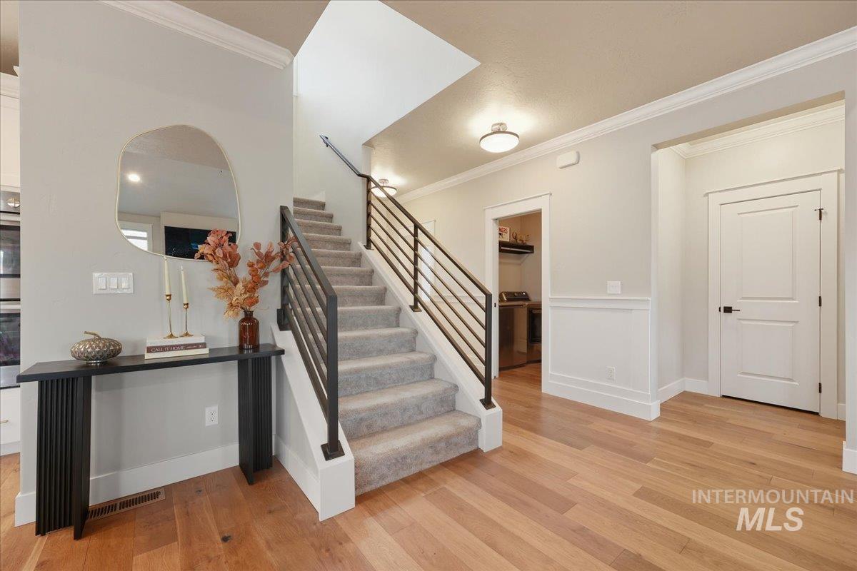 Stairs with ornamental molding and wood finished floors