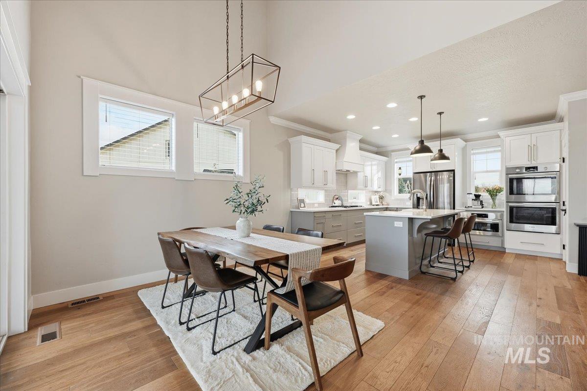 Dining area featuring light wood-type flooring, recessed lighting, and crown molding
