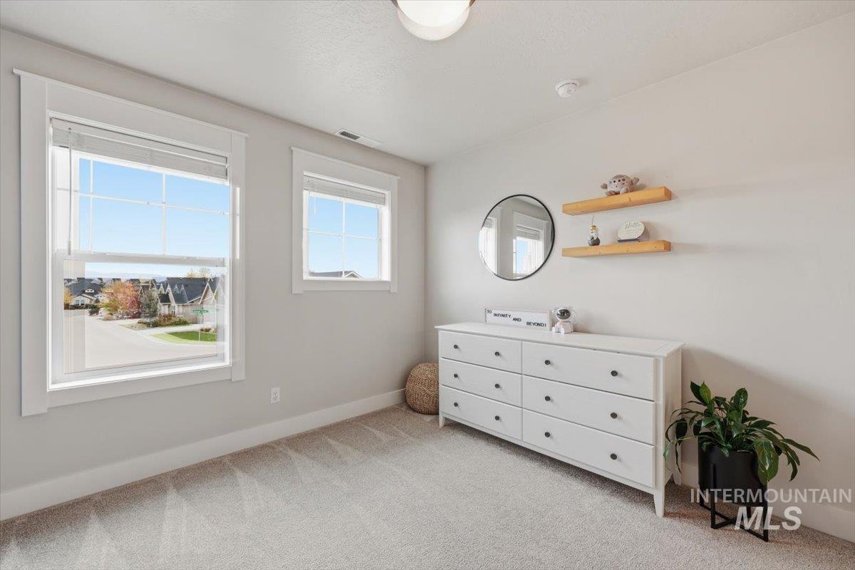 Bedroom with light carpet and baseboards